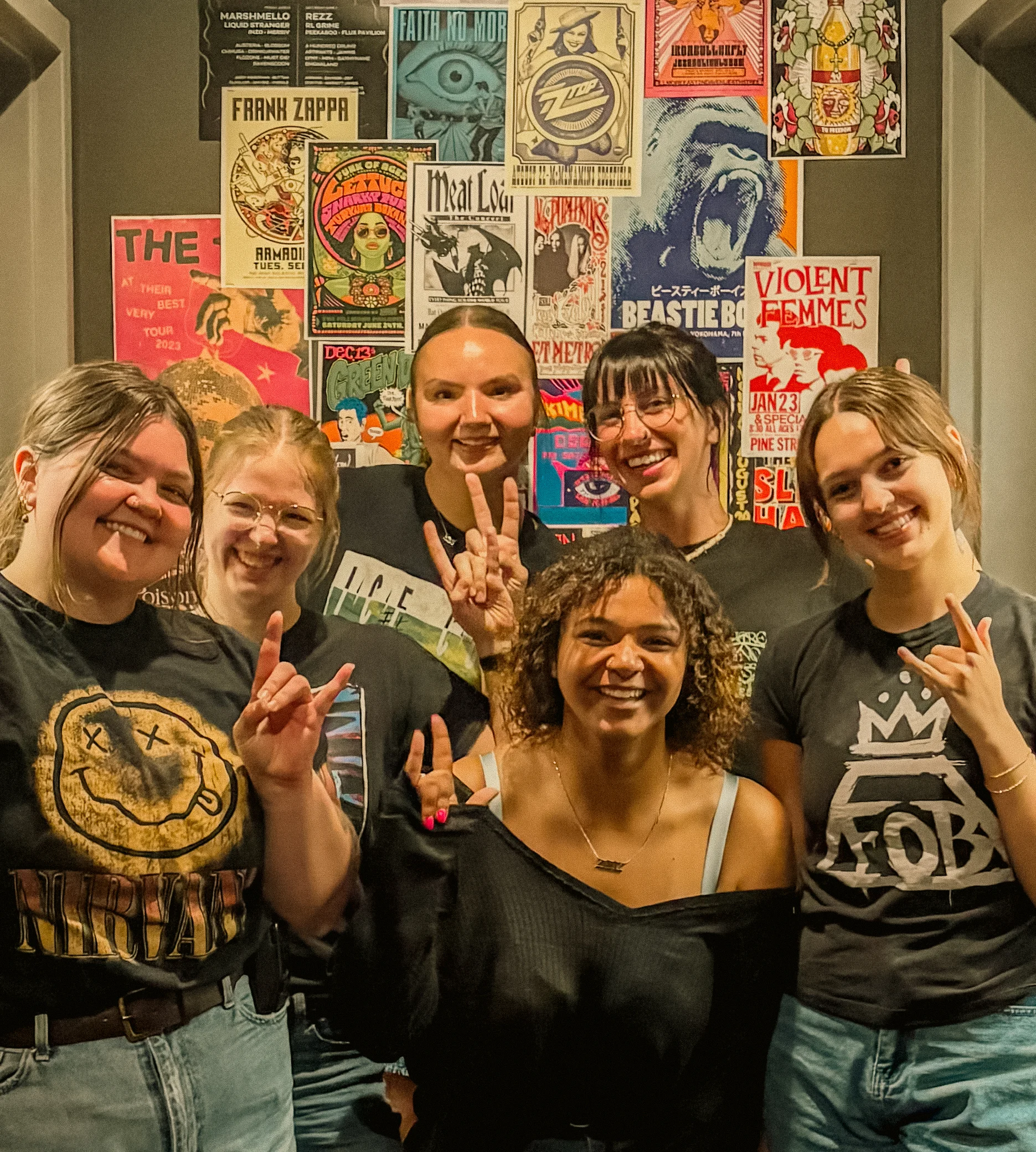 Staff posing together by our concert poster wall