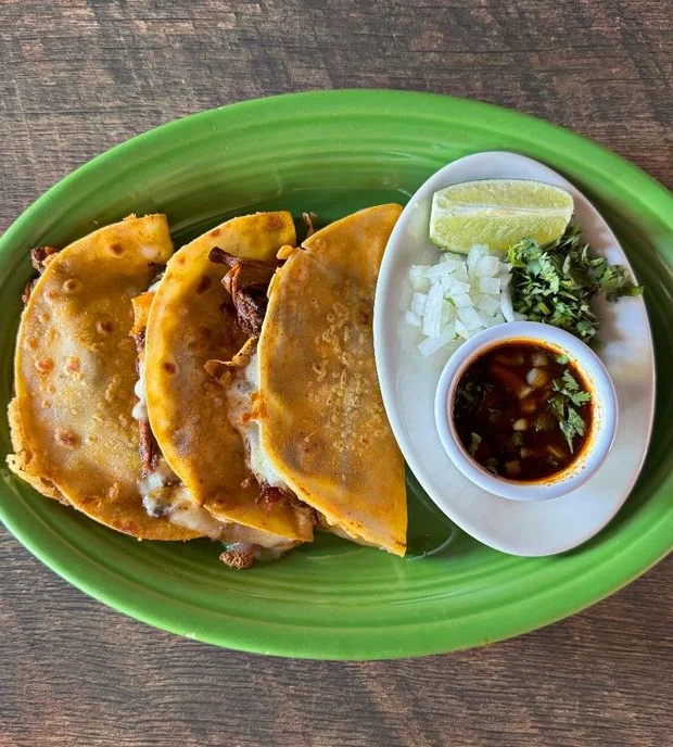Delicious birria tacos served with fresh toppings and sauces.