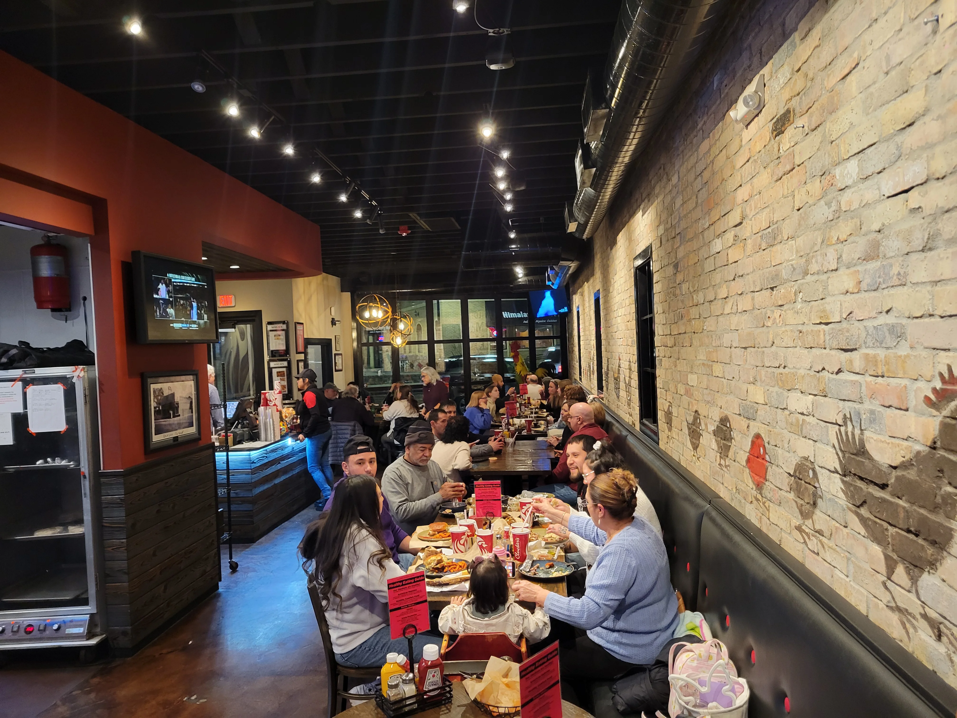 Cozy restaurant interior with diners enjoying meals and warm lighting