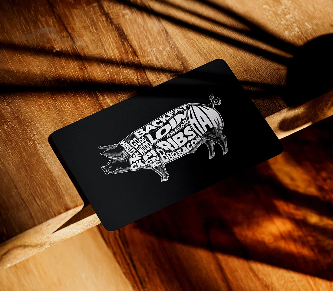 Artistic pig illustration with BBQ terms on a black card