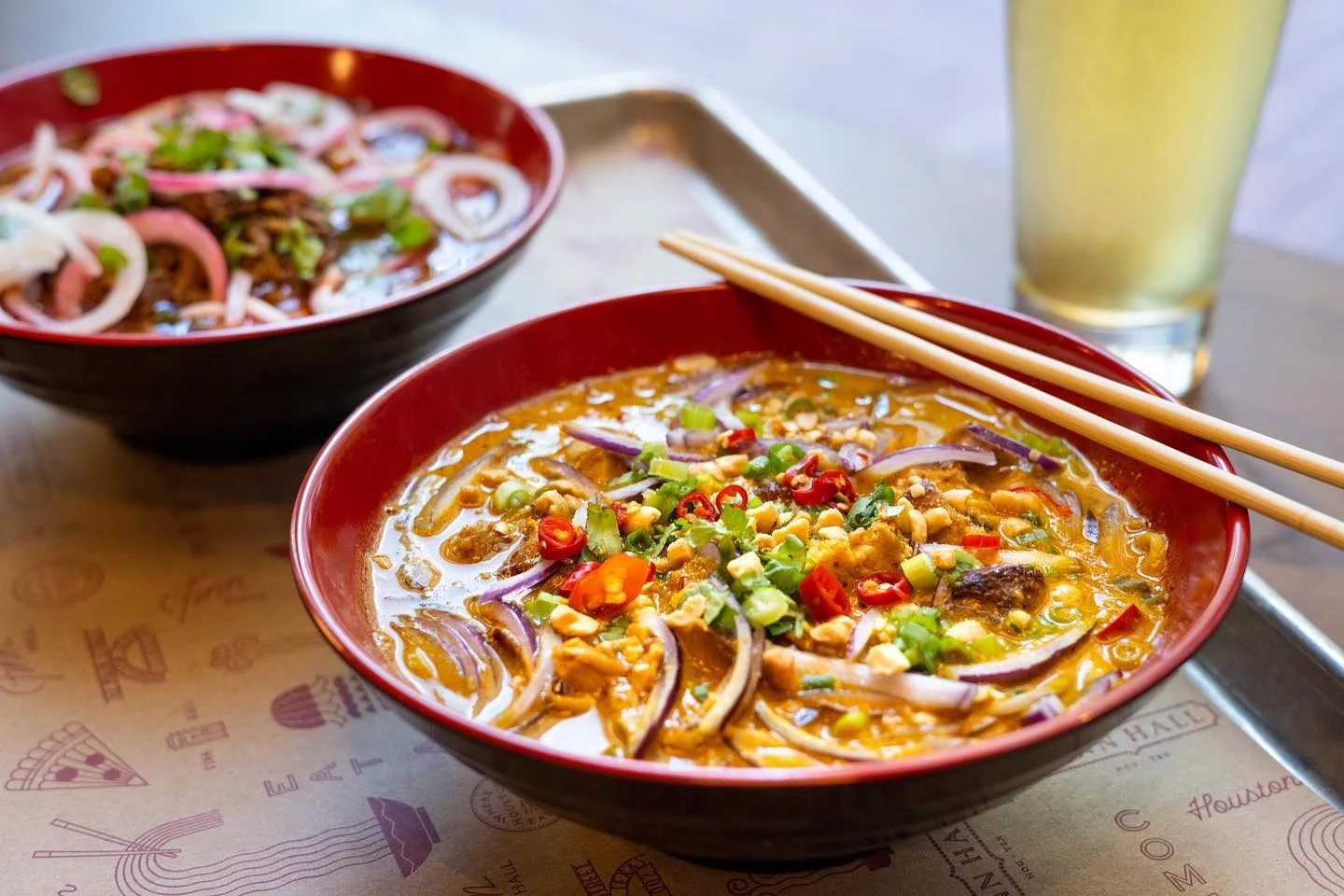 Bowl of spicy Thai khao soi with fresh herbs