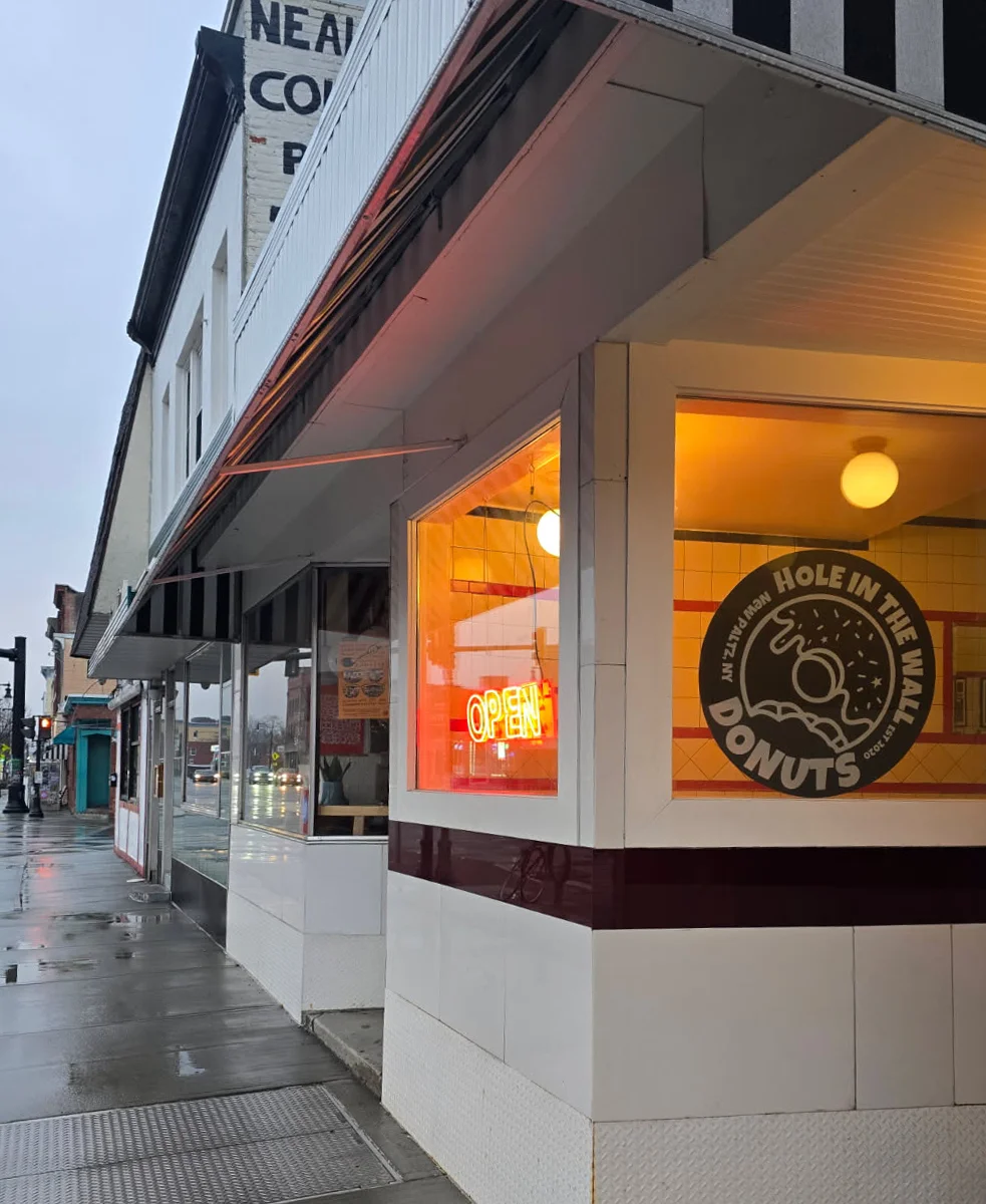 Exterior view of HITW Kingston restaurant with vibrant signage.