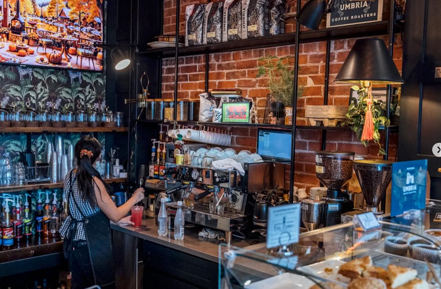 Bartender preparing drinks in a stylish café with brick walls