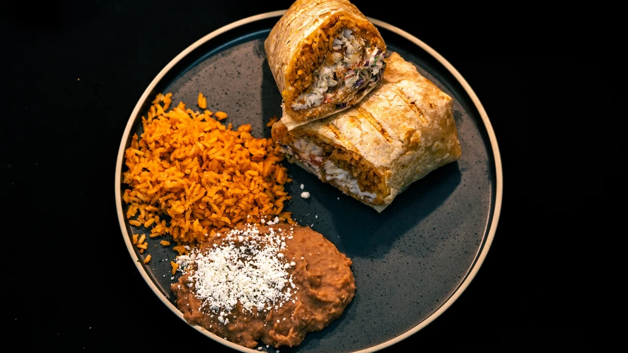 A plate of quesadillas featuring golden-brown tortillas filled with cheese and herbs, accompanied by a fresh salad and dipping sauces.