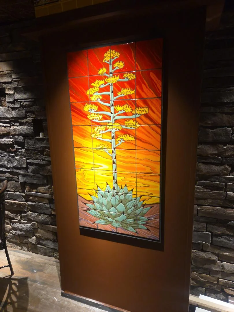 Colorful tile mural of an agave plant in a warm restaurant setting