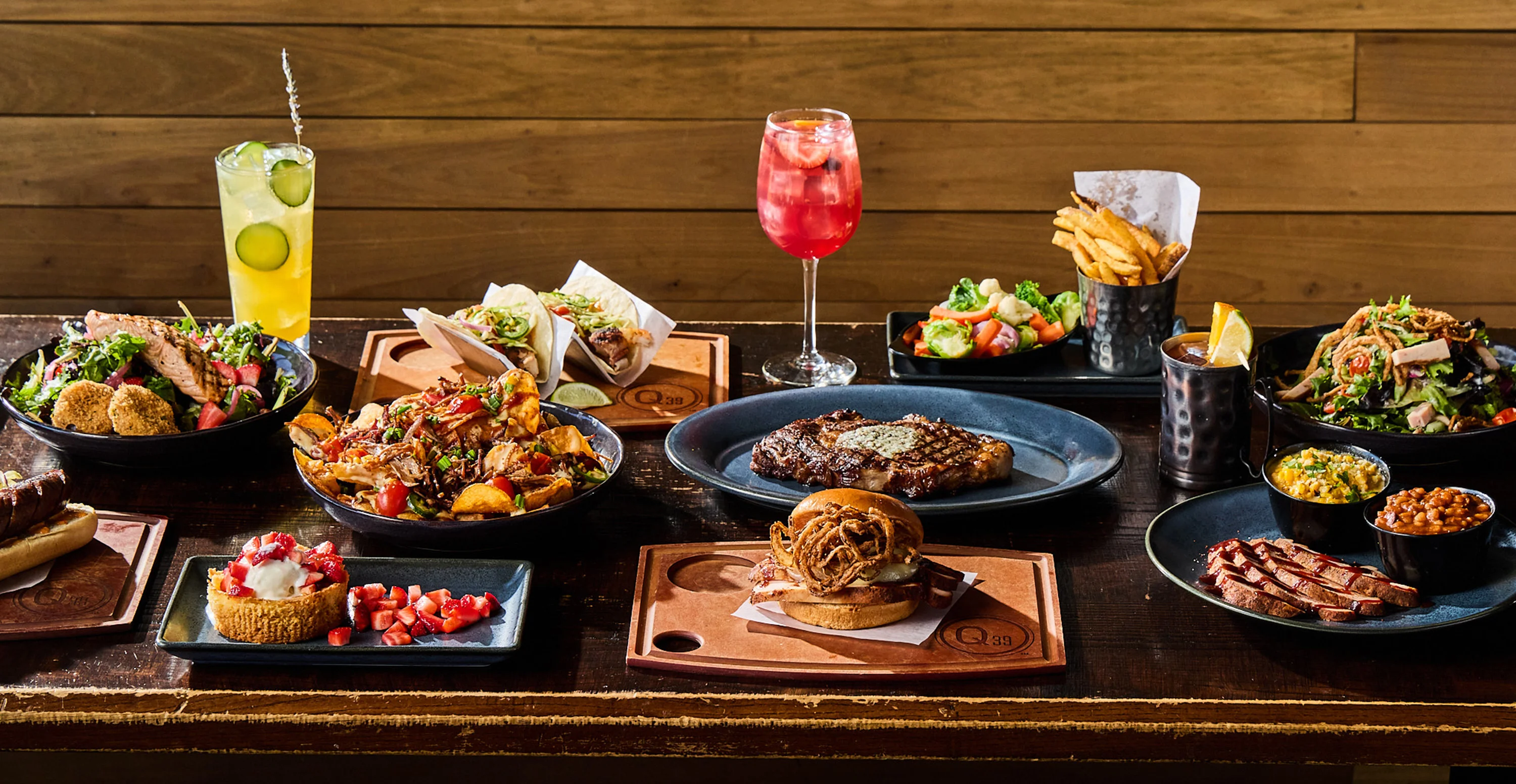 Variety of American barbecue dishes and cocktails on a rustic table