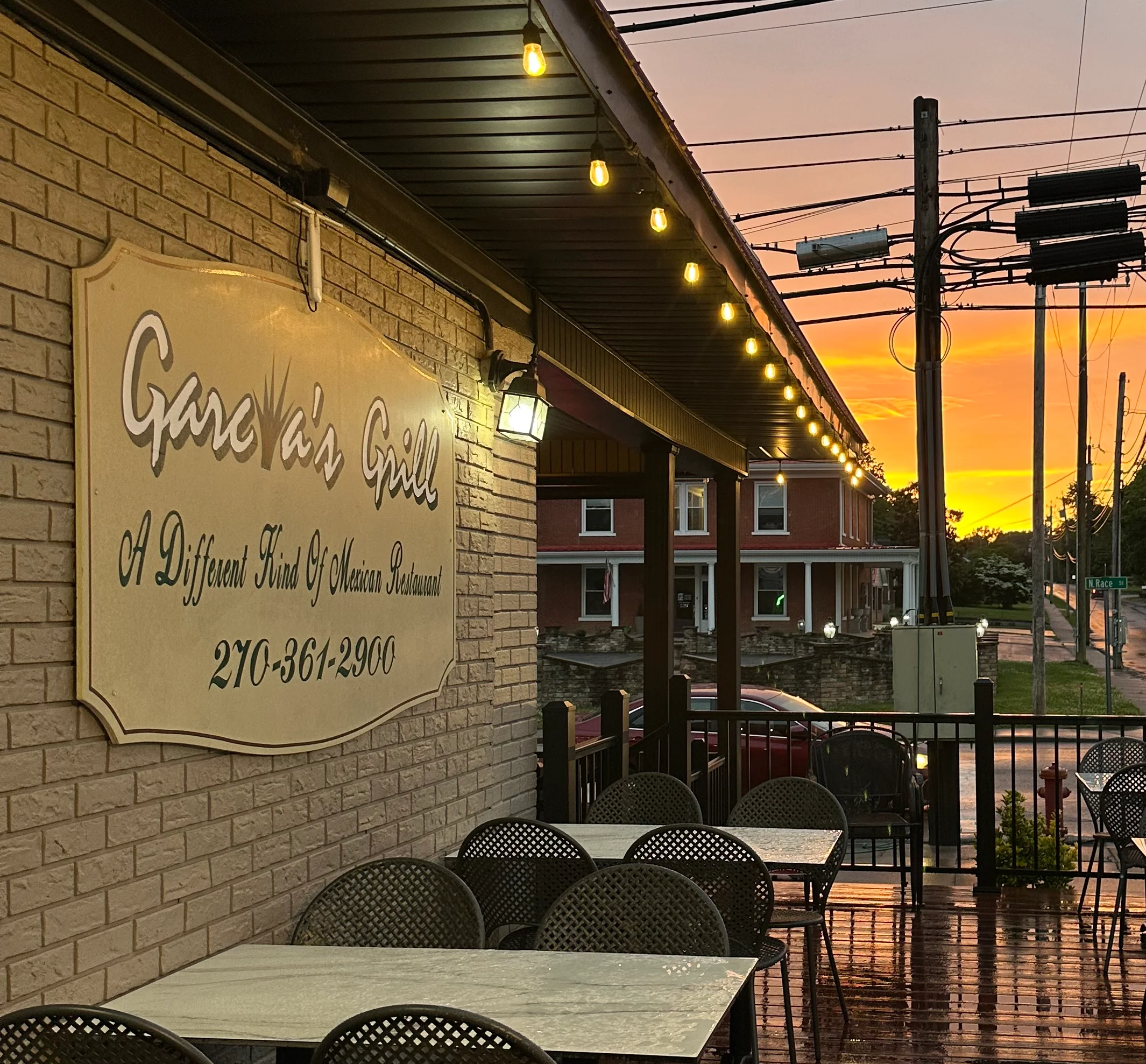 Outdoor dining area with tables and sunset view