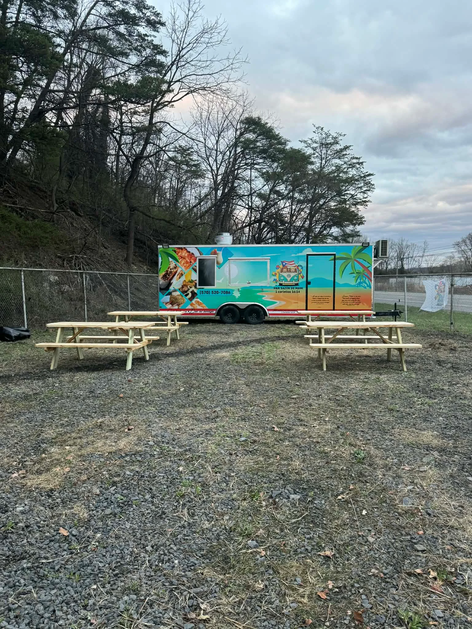 Colorful food truck with picnic tables in a natural setting