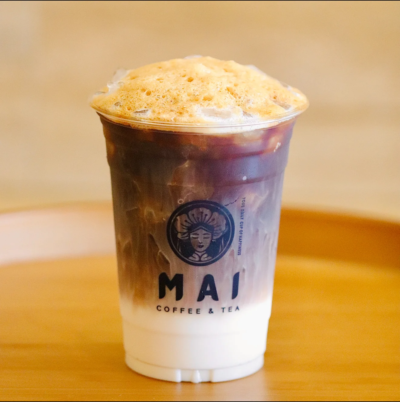 Iced coffee with creamy foam topping from a specialty café