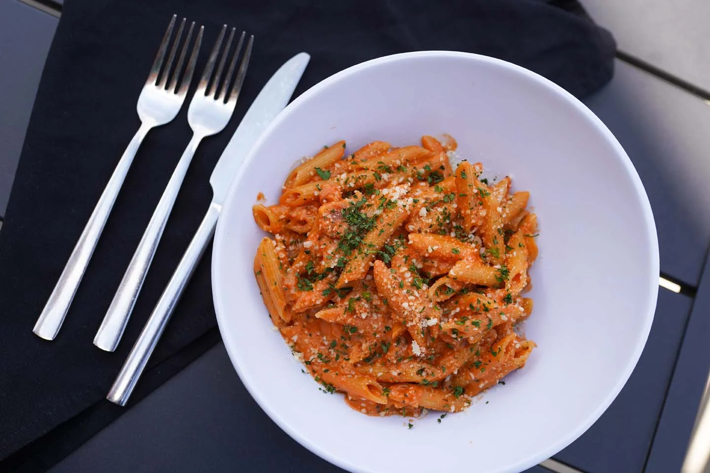 Creamy penne alla vodka topped with herbs