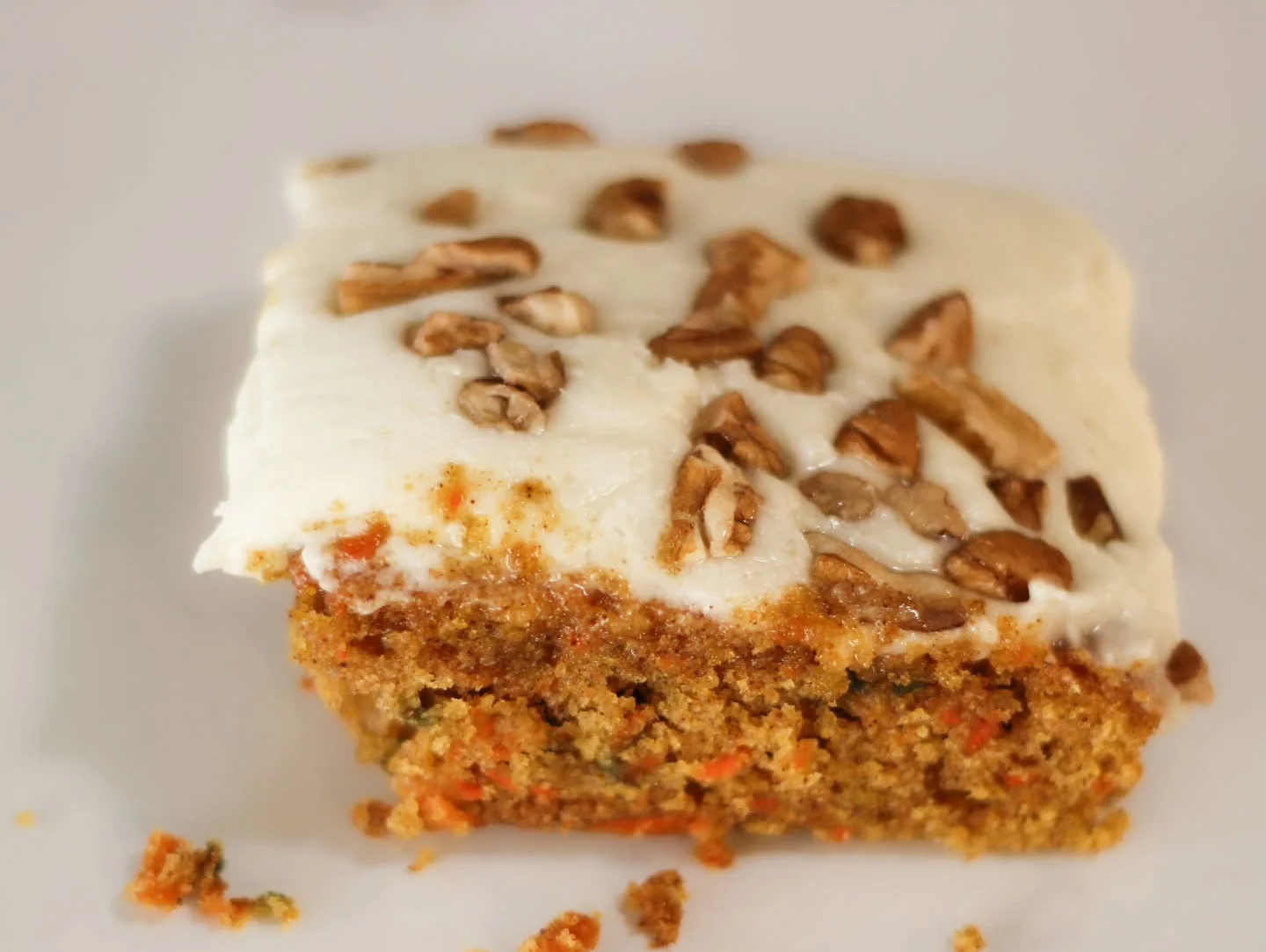 Delicious carrot cake slice with cream cheese frosting and pecans