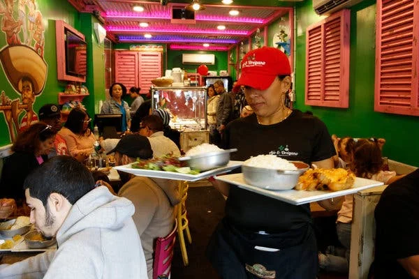 Vibrant restaurant scene with a server carrying plates of Mexican food