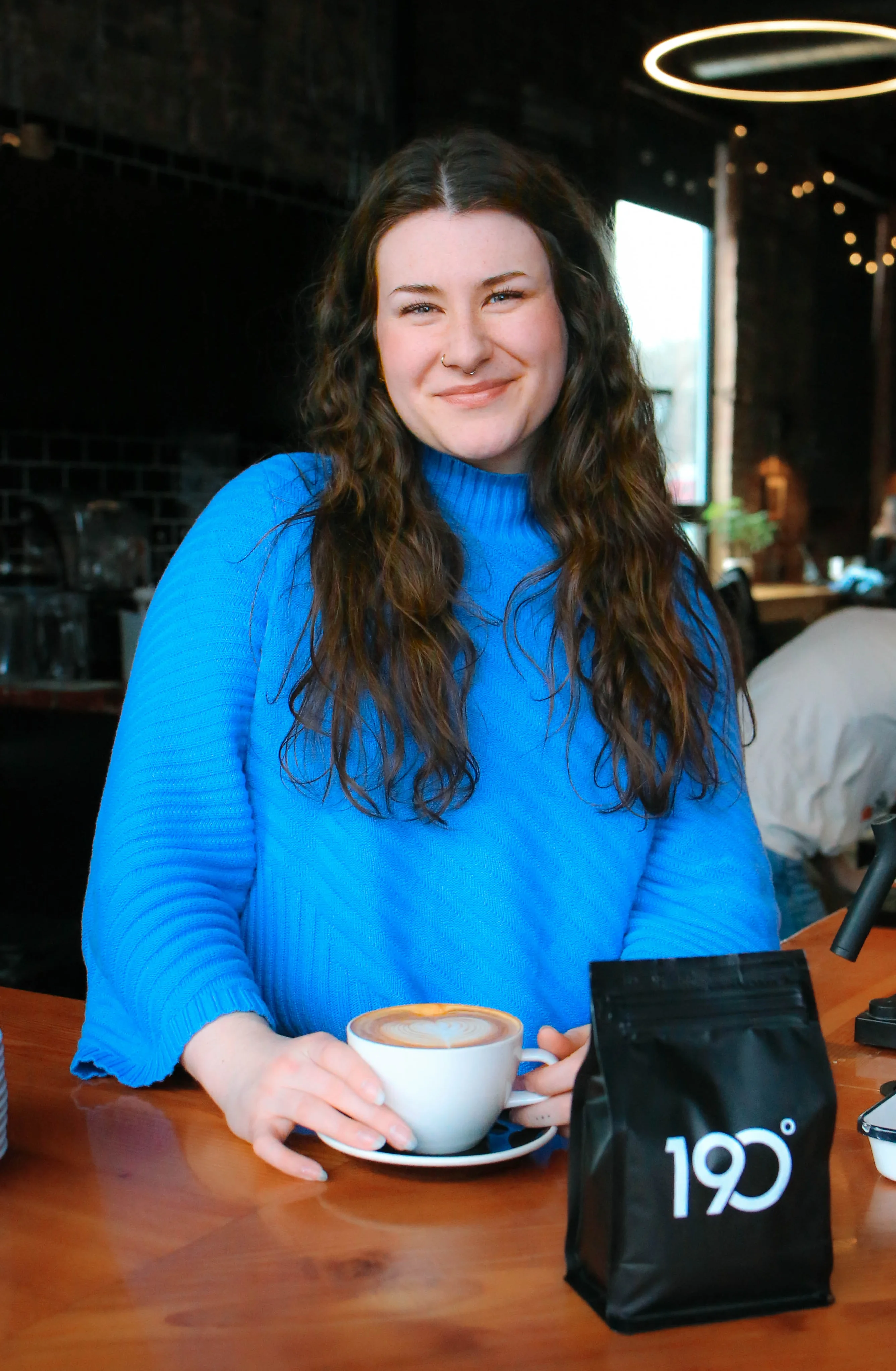 Barista serving a latte in a cozy café setting