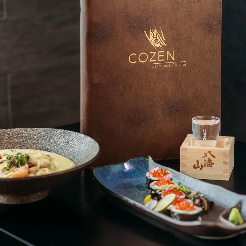 An inviting restaurant interior showcasing a bar area, modern lighting, and neatly arranged tables with menus.