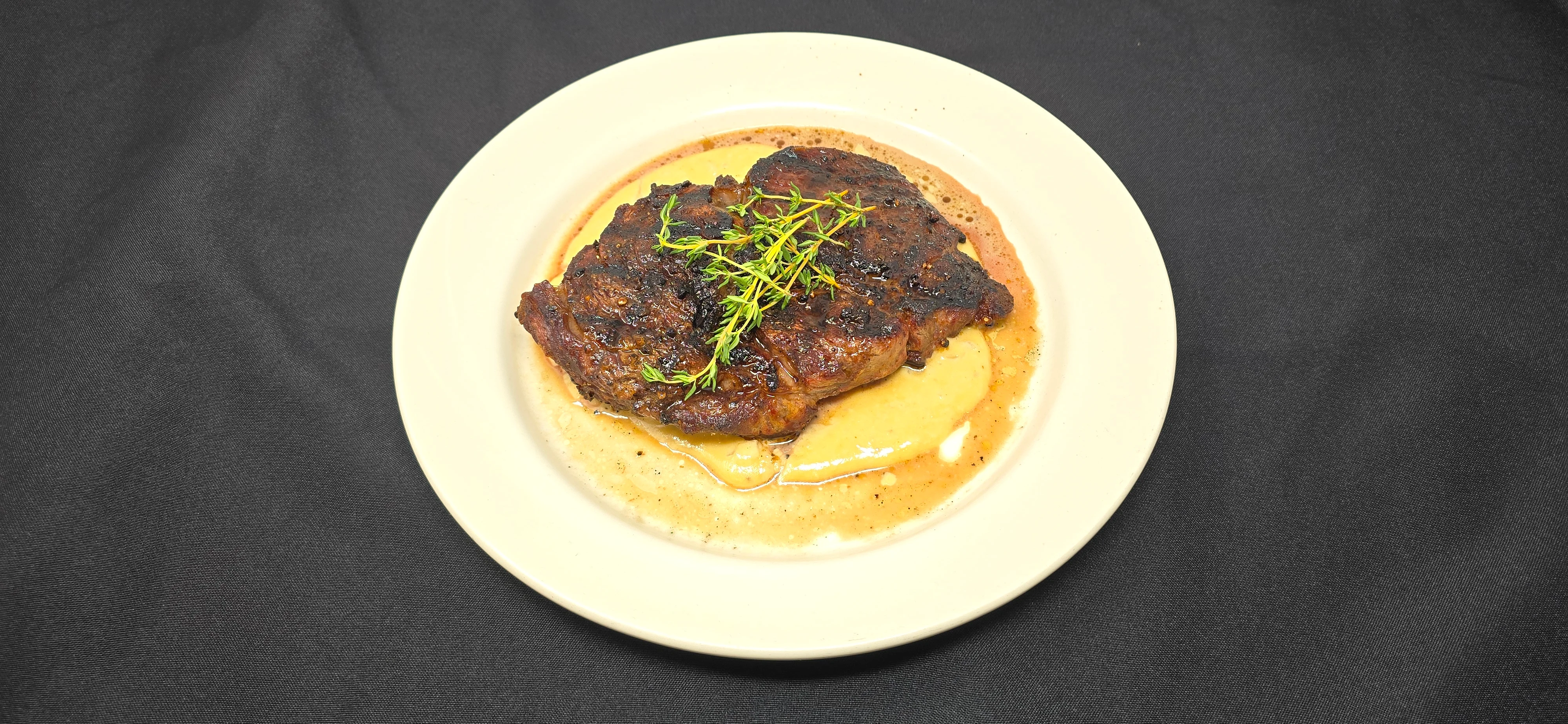 Grilled steak with creamy sauce and herbs on a plate