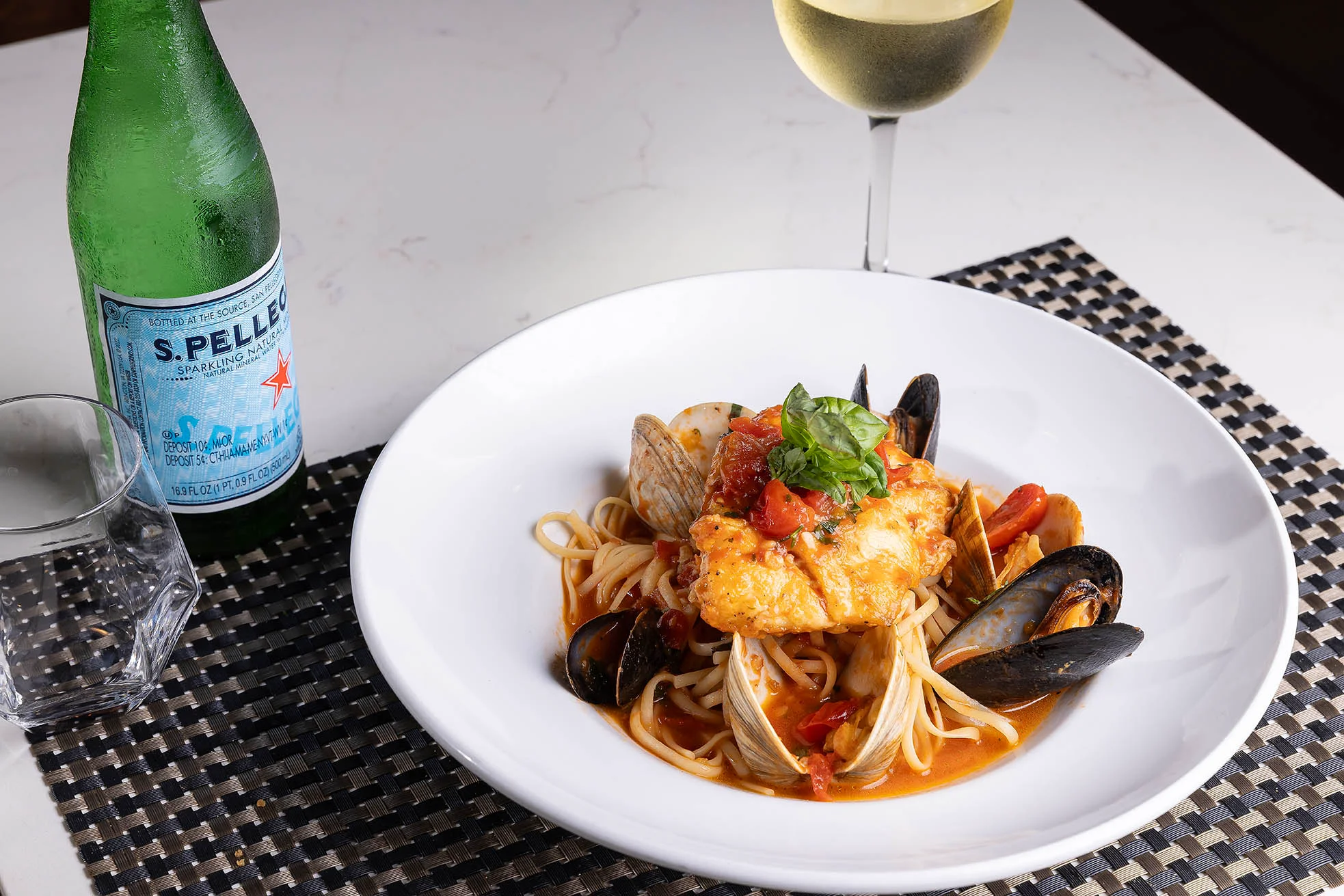 Cucina clam and mussel pasta paired with sparkling water