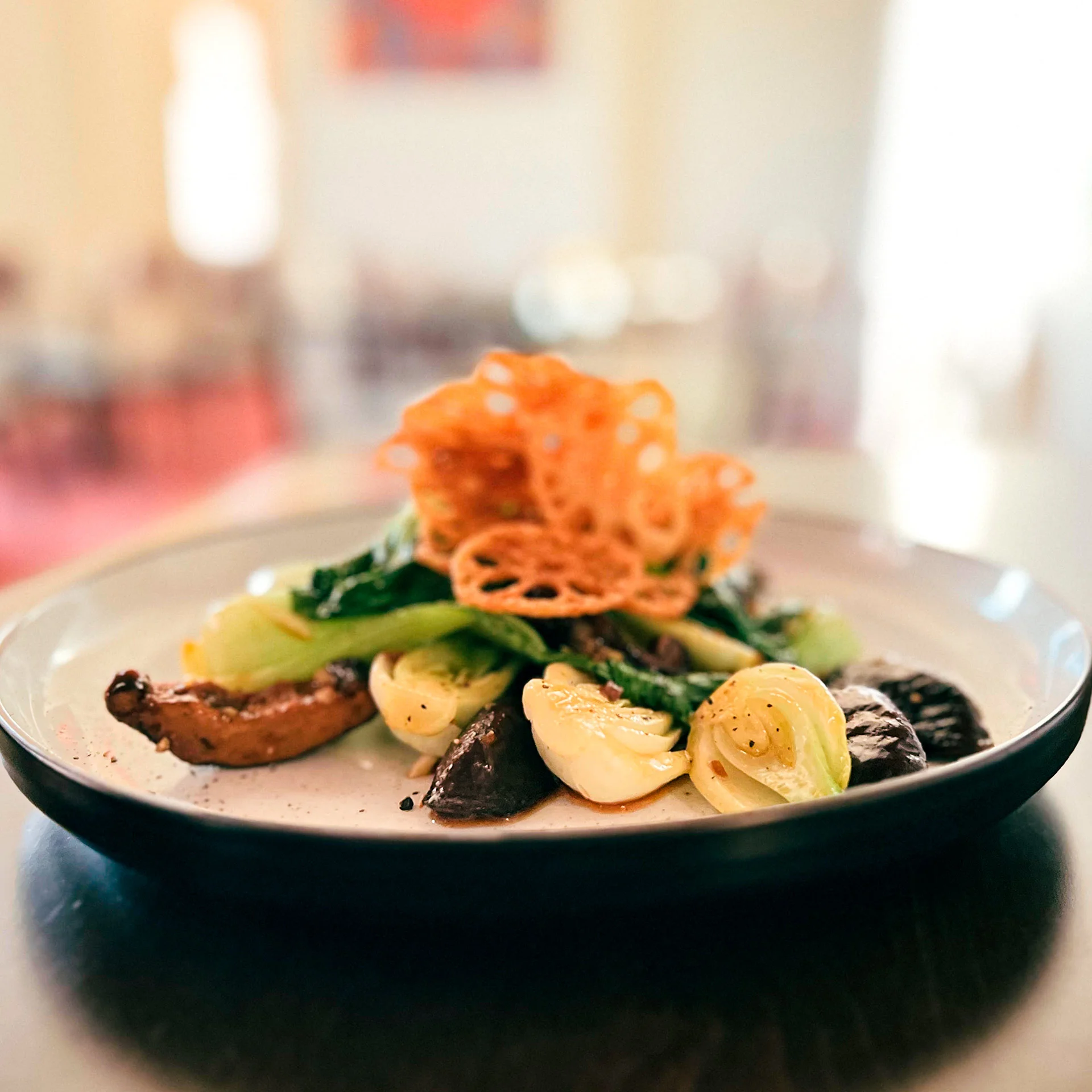 Artfully plated Asian-inspired vegetable dish with crispy garnish