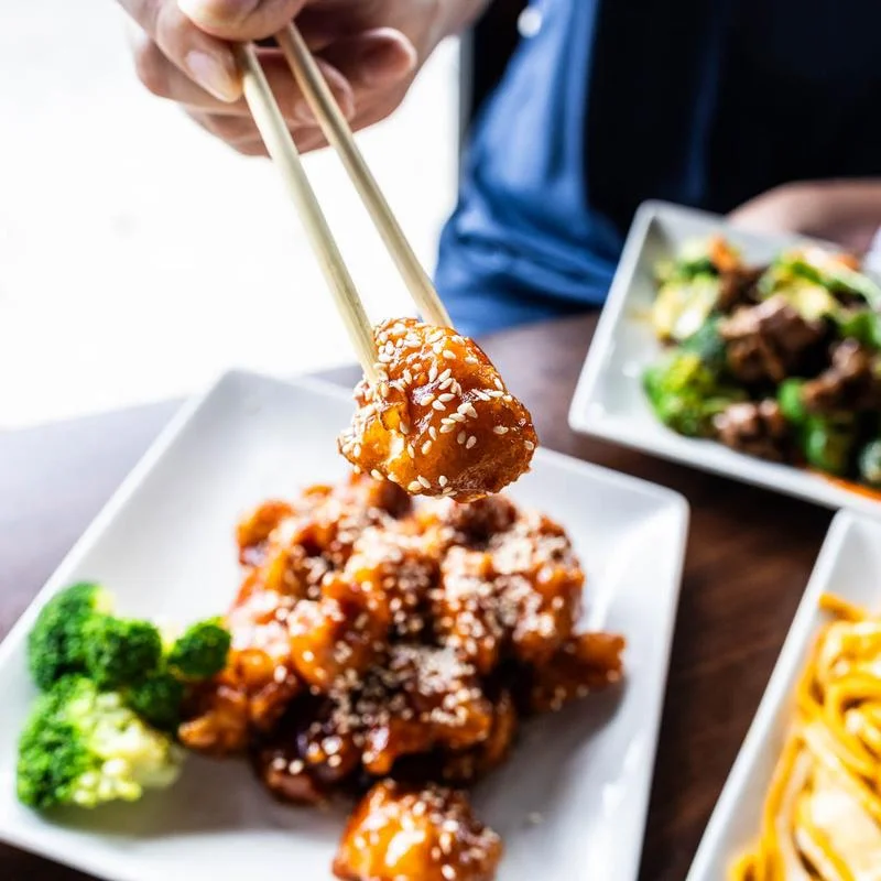 Sweet and sour chicken with broccoli on a white plate