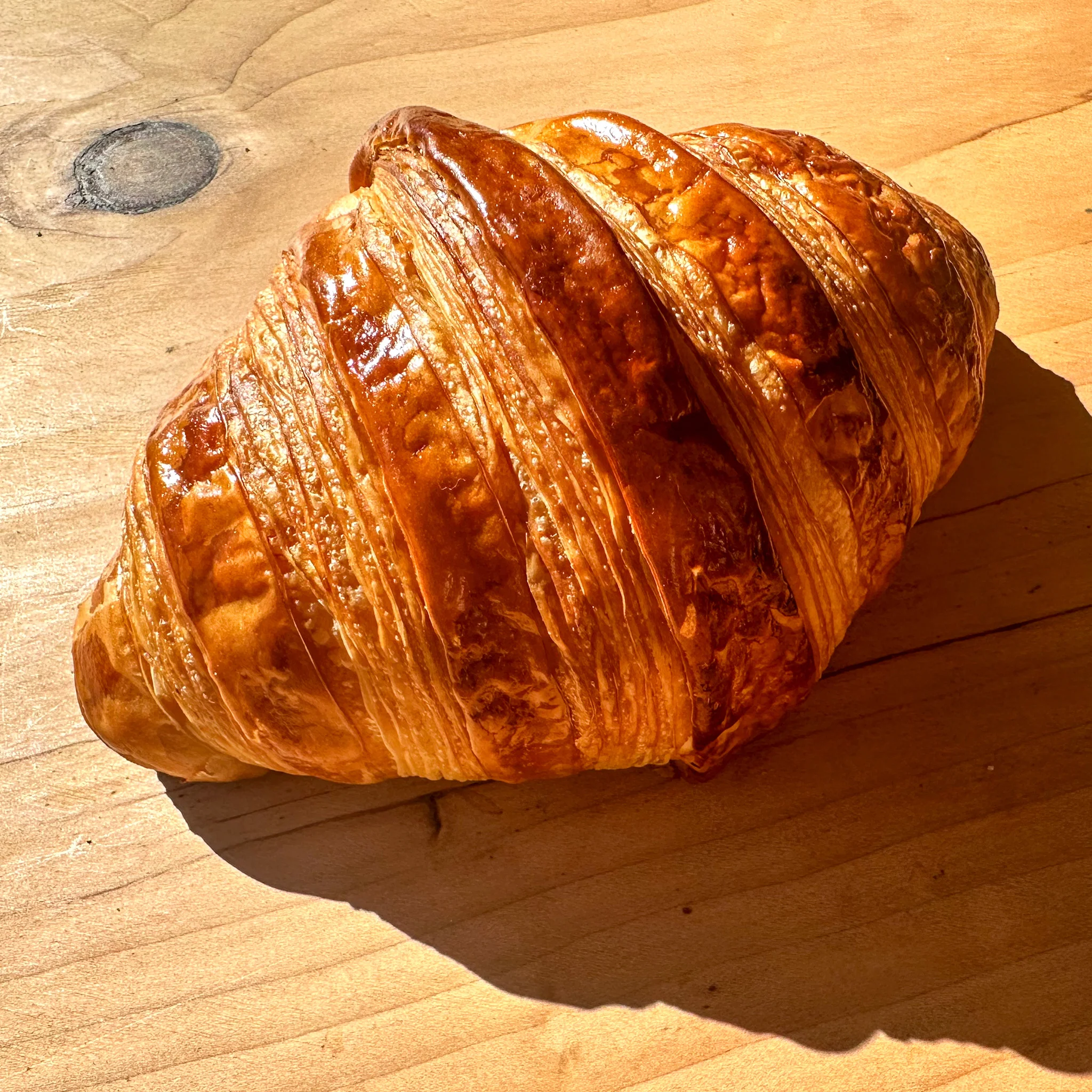 Golden French croissant on a wooden table