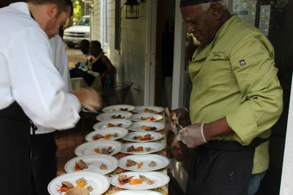 Chefs plating Caribbean-inspired dishes outdoors