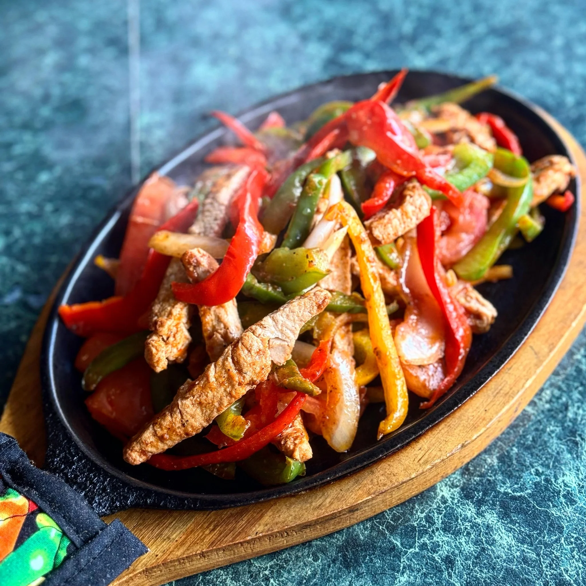 Sizzling fajitas served on a hot skillet