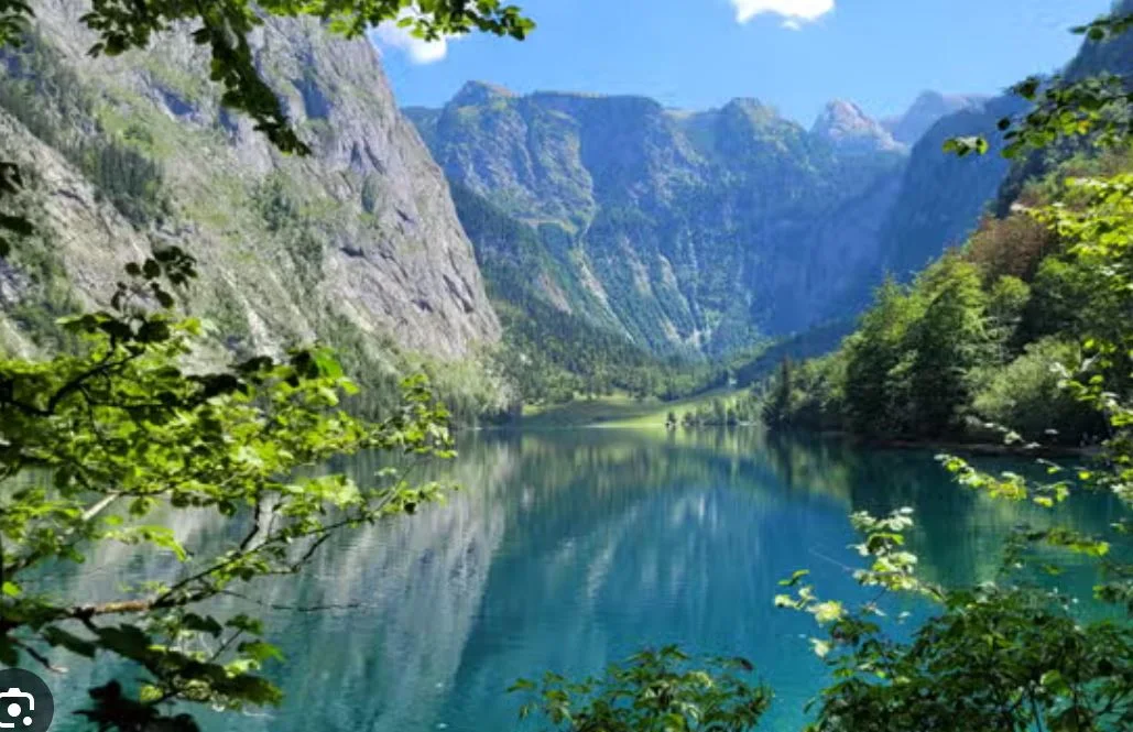 Scenic mountain lake surrounded by lush greenery and towering cliffs