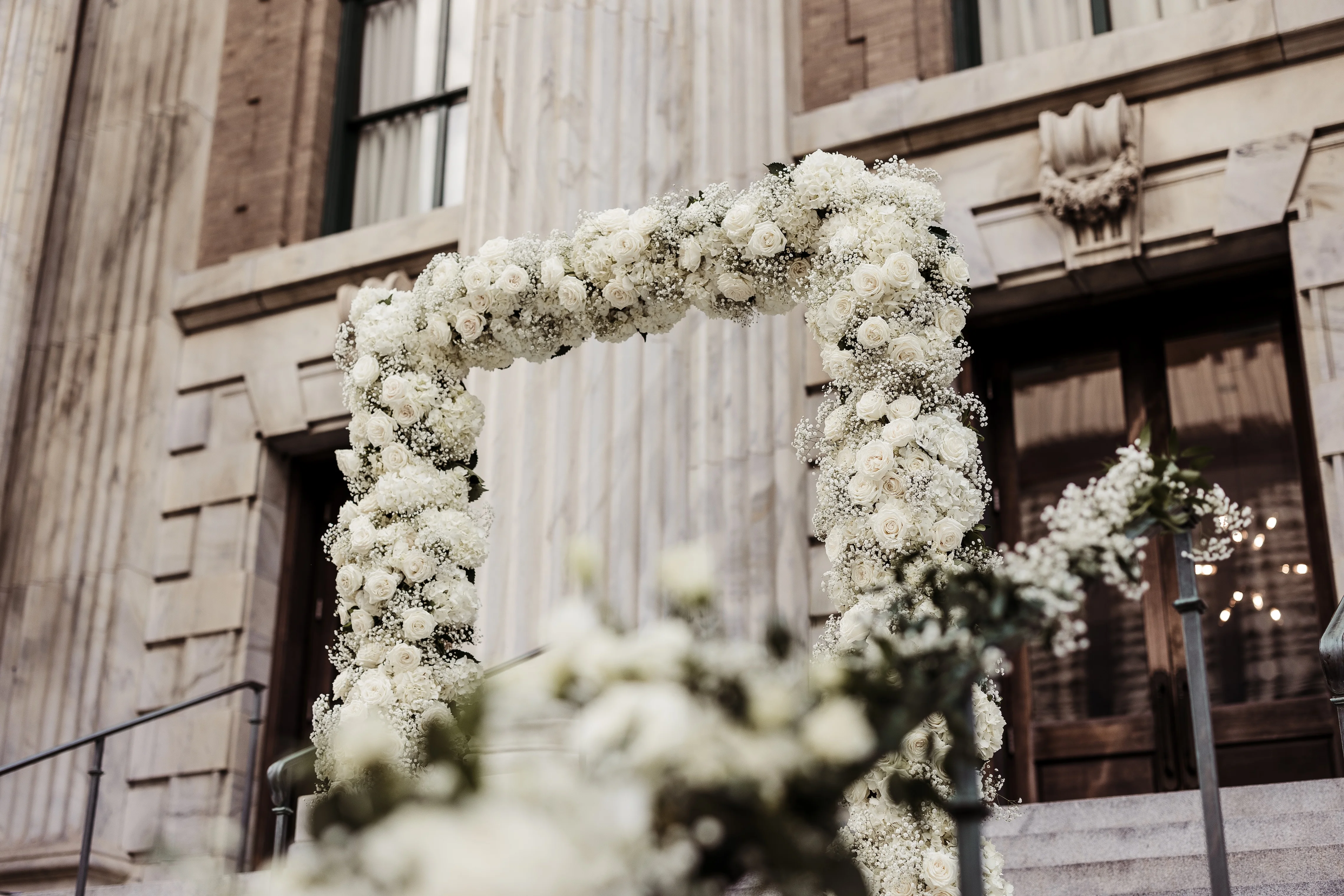 Elegant floral archway adorned with white roses for a wedding ceremony