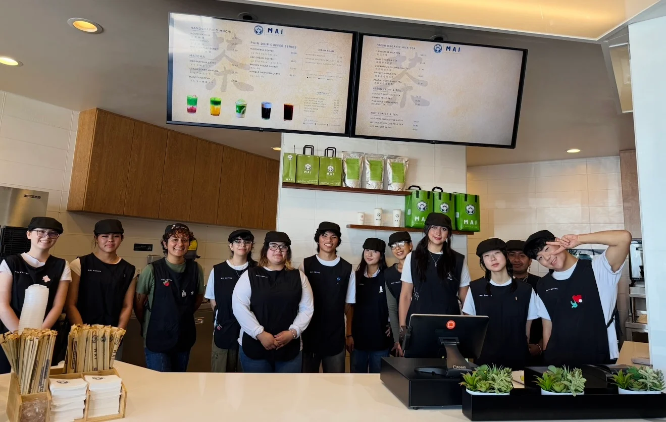 Staff at a modern café with menu displays and fresh ingredients