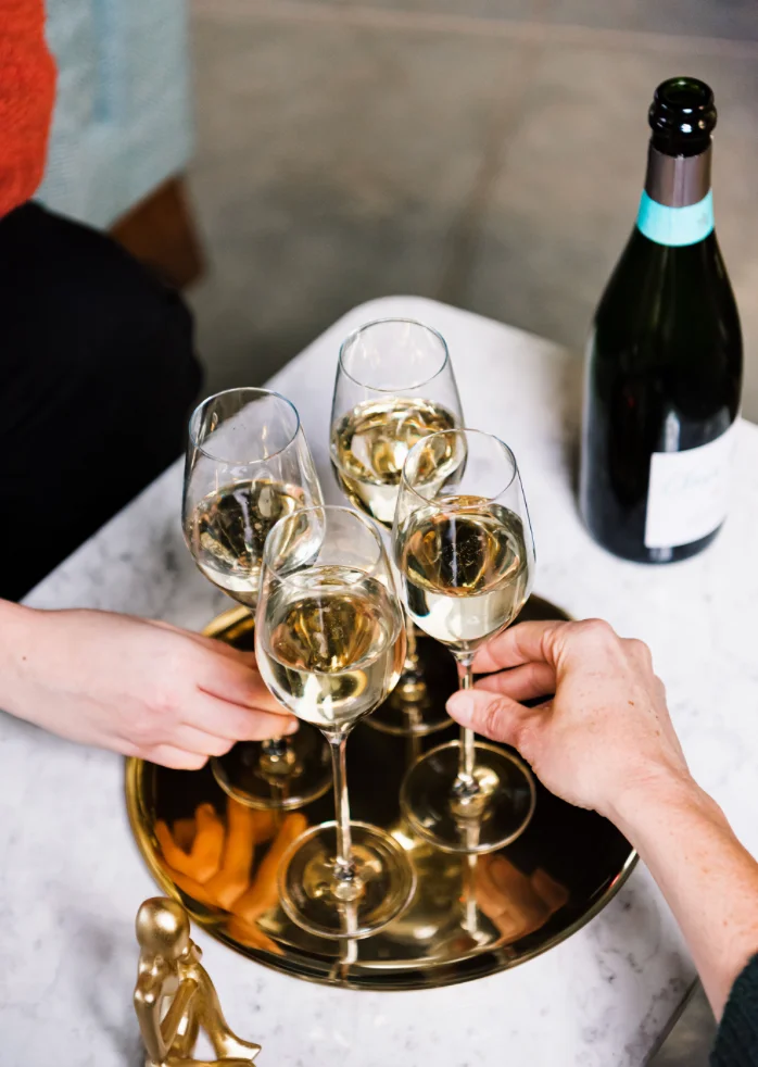 Cheers with sparkling wine in elegant glasses on a gold tray