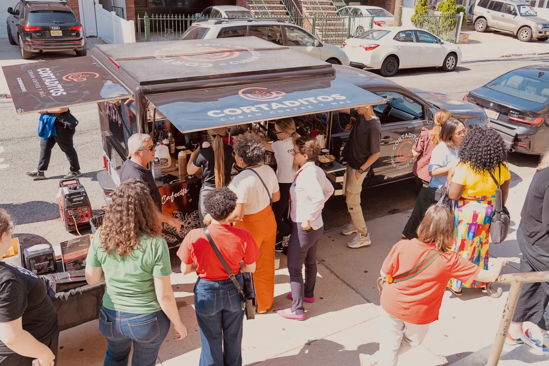 Crowd gathered around a vibrant food truck serving Cuban coffee