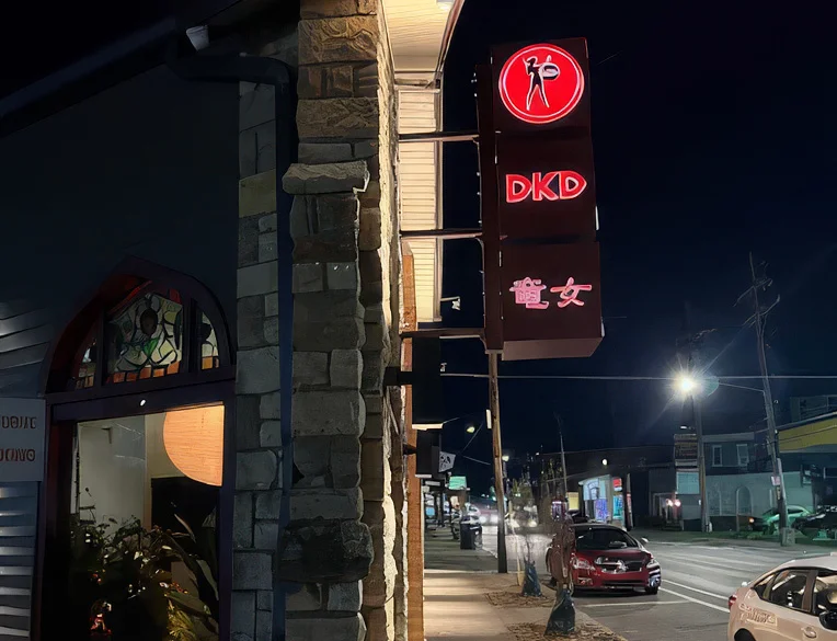 Exterior view of DKD restaurant at night with illuminated signage
