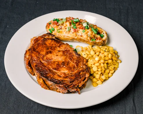 Grilled barbecue beef brisket with corn and loaded potato