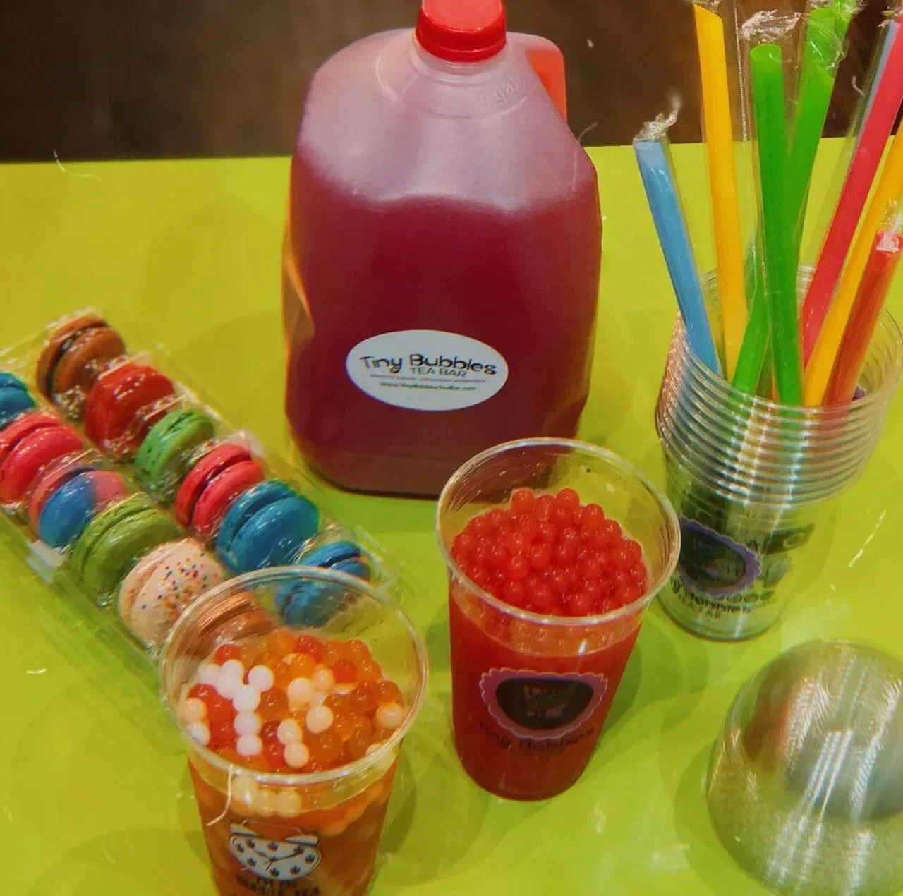 Colorful bubble tea setup with macarons and vibrant straws