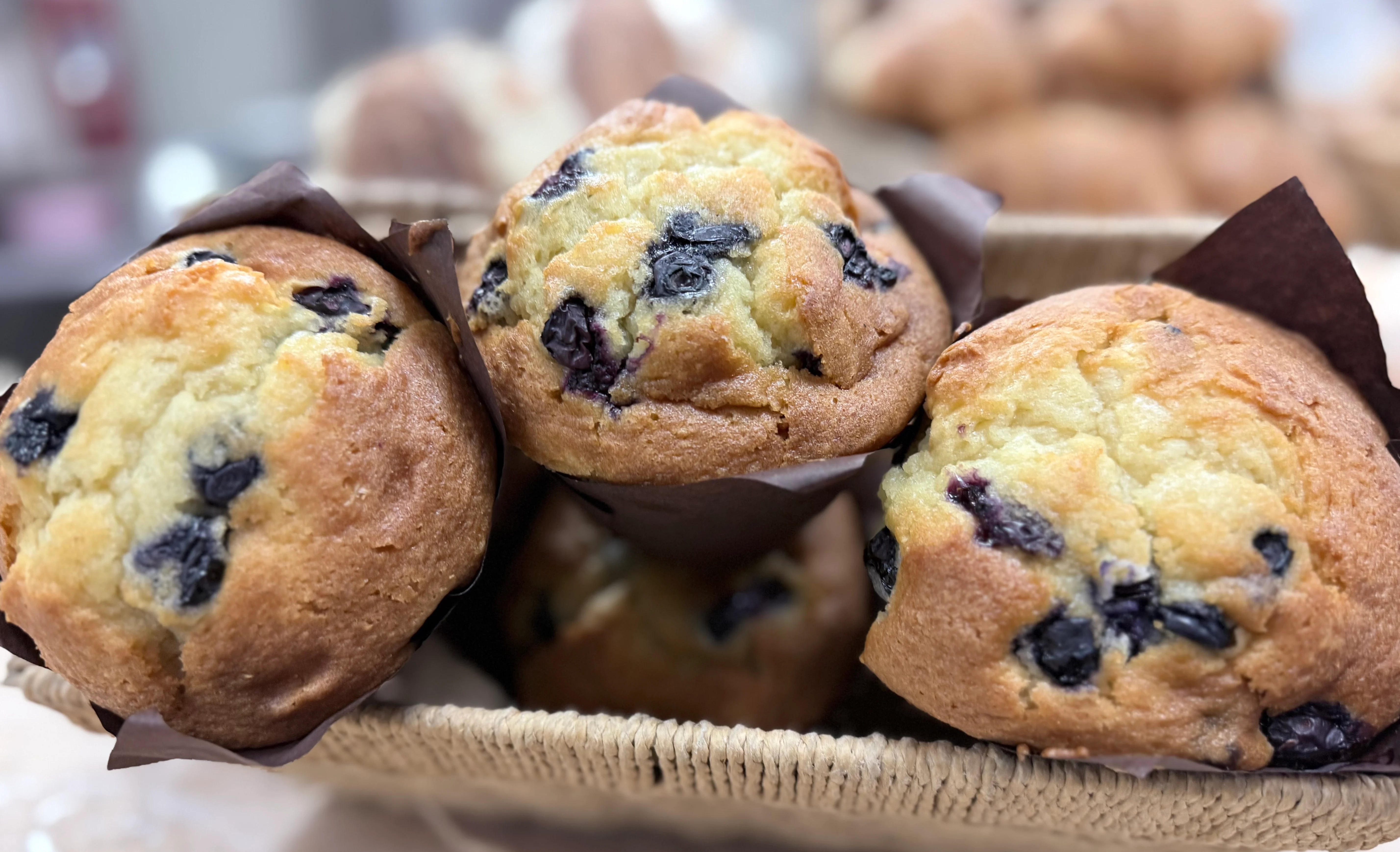 Freshly baked blueberry muffins in a woven basket