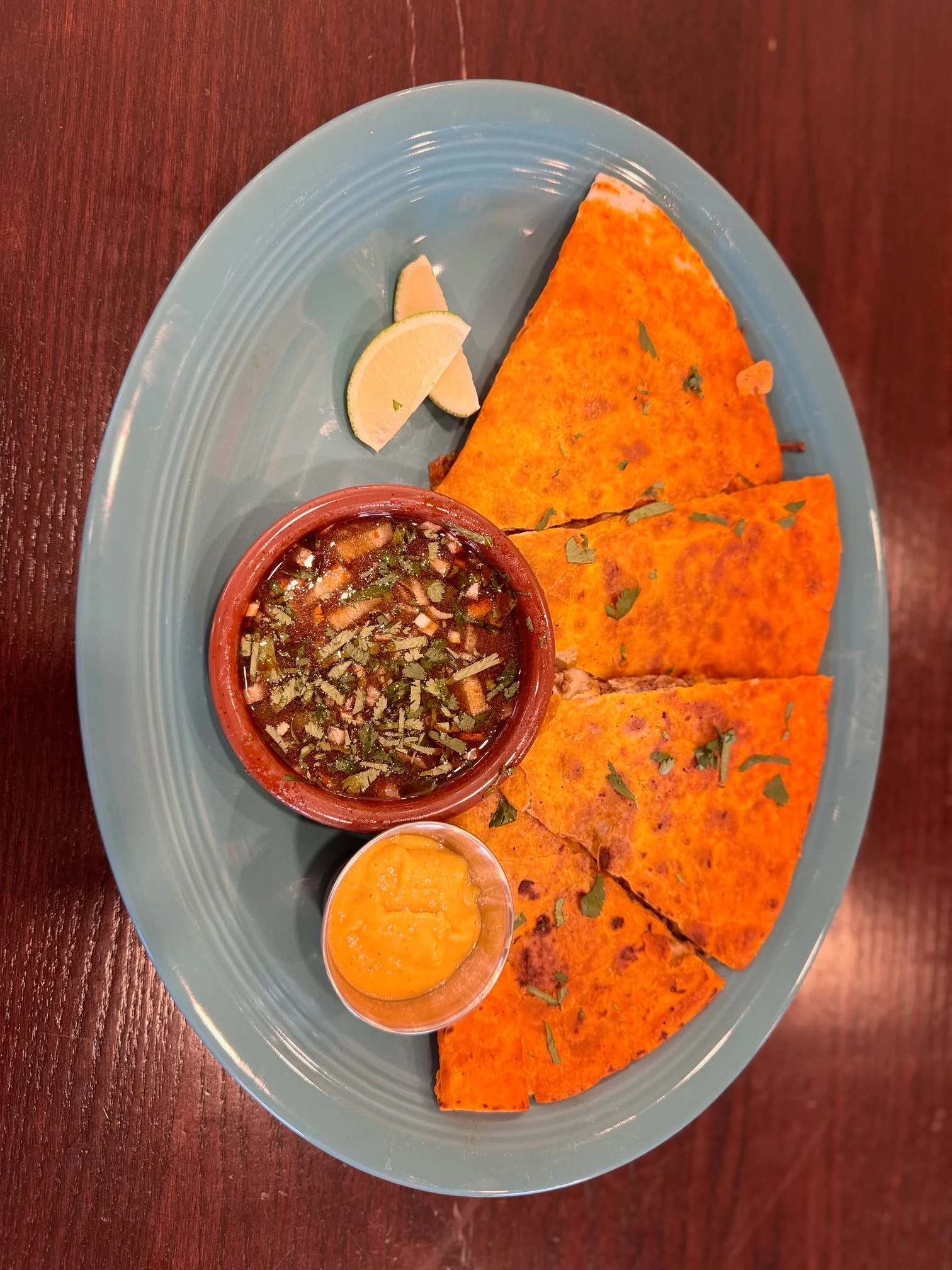 Colorful Indian paratha served with chutney and lime wedges