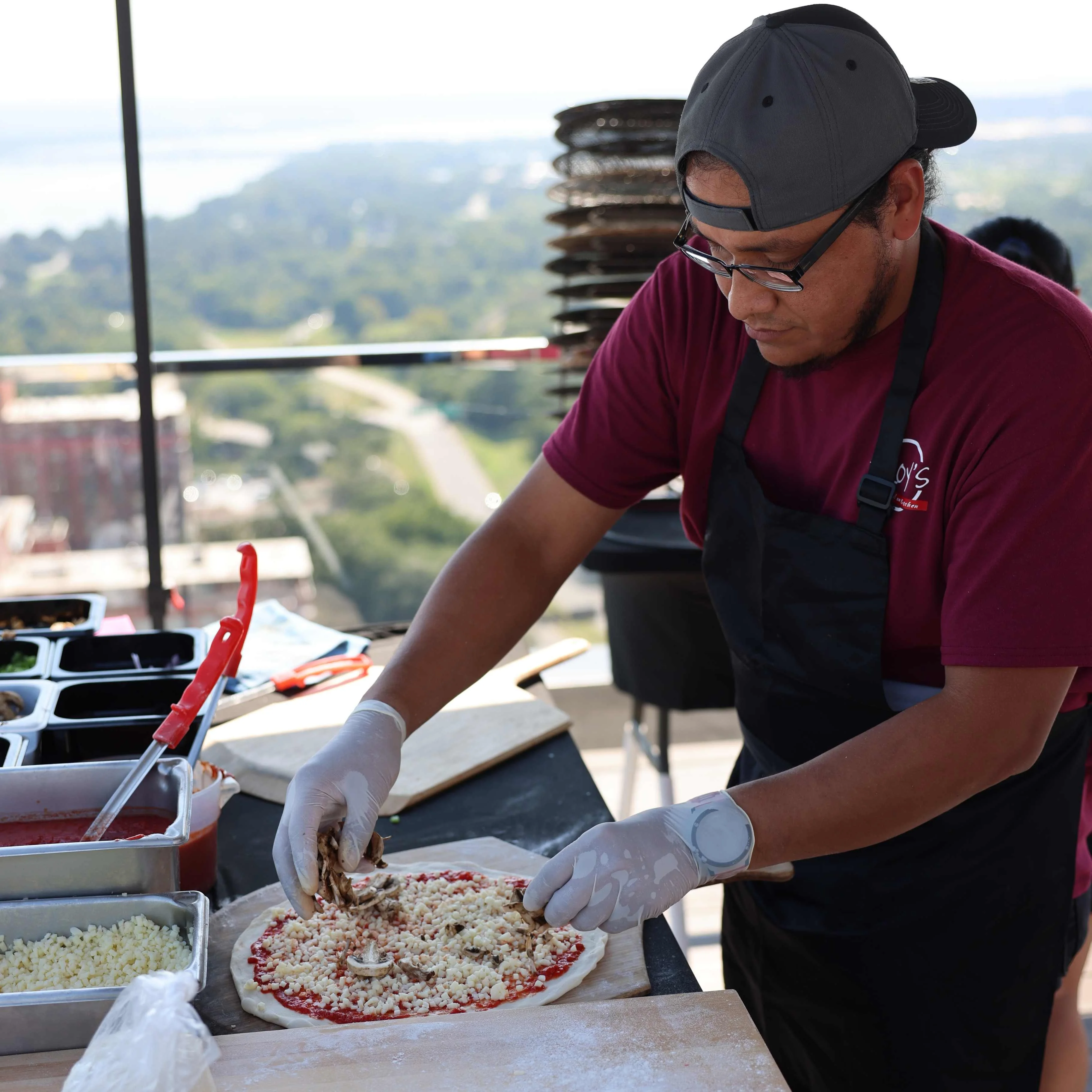 A team member prepping a slice of pizza