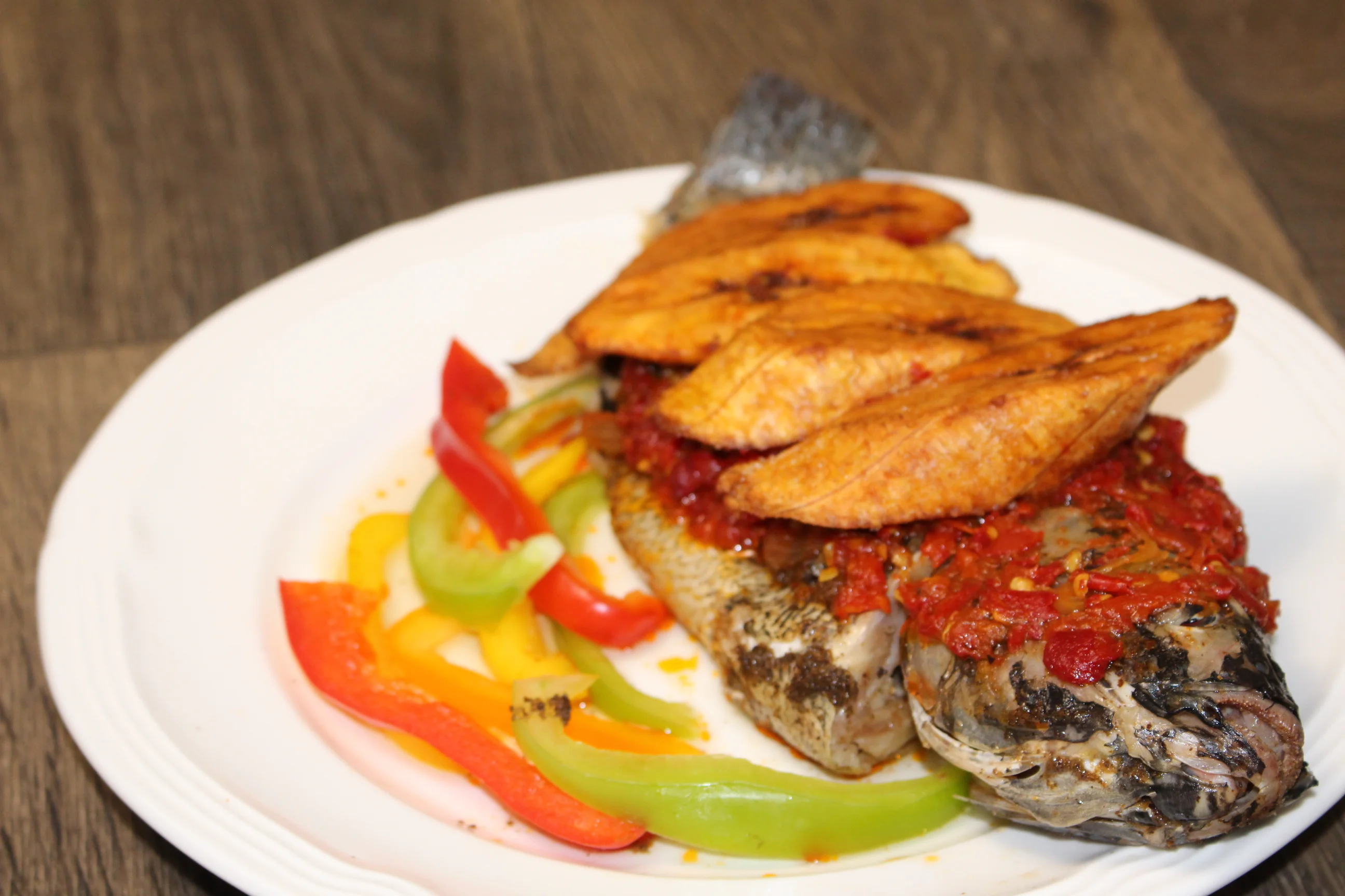 Grilled fish with plantains and spicy sauce, a popular West African dish