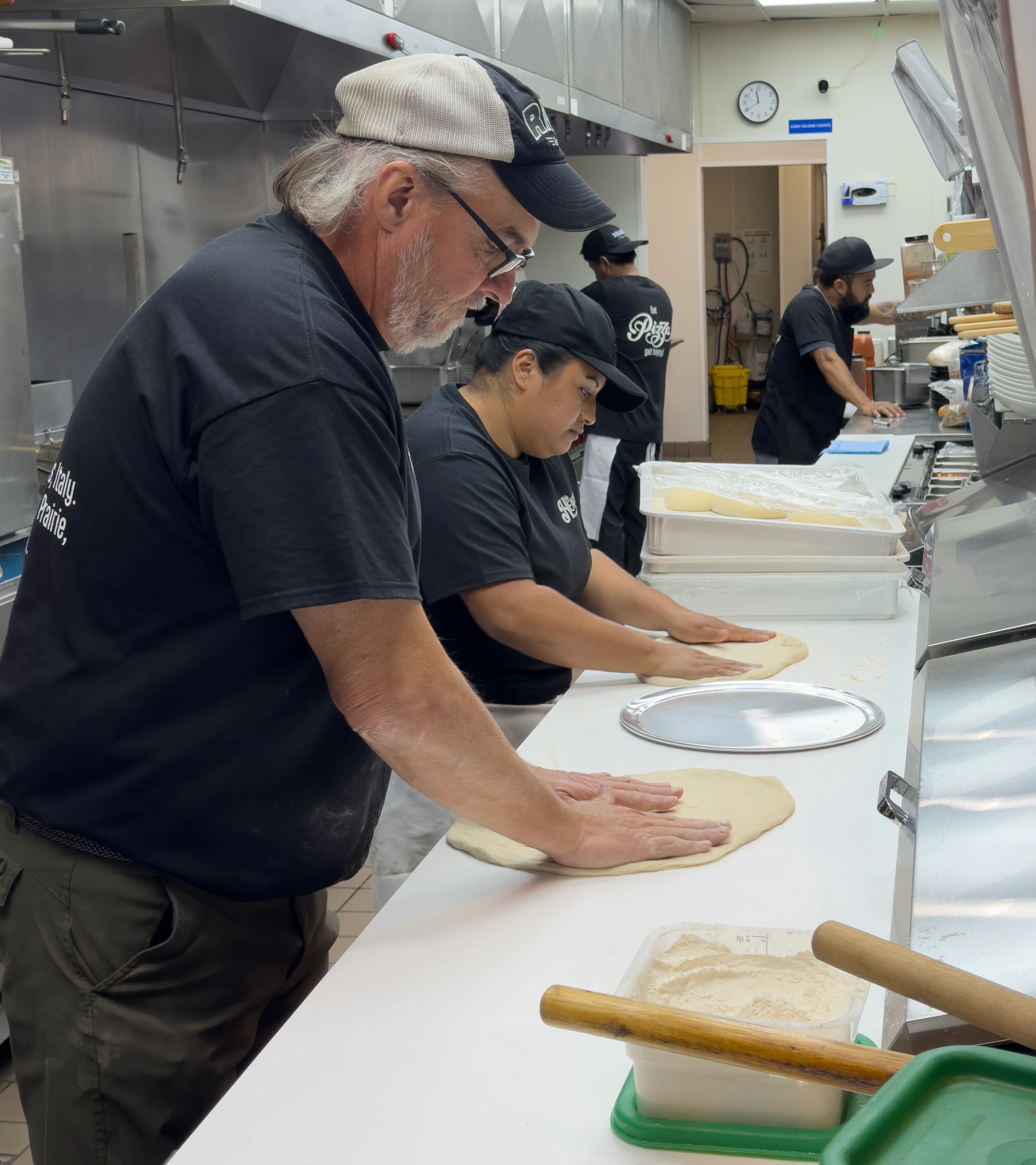 A team of skilled pizza chefs creating pizza