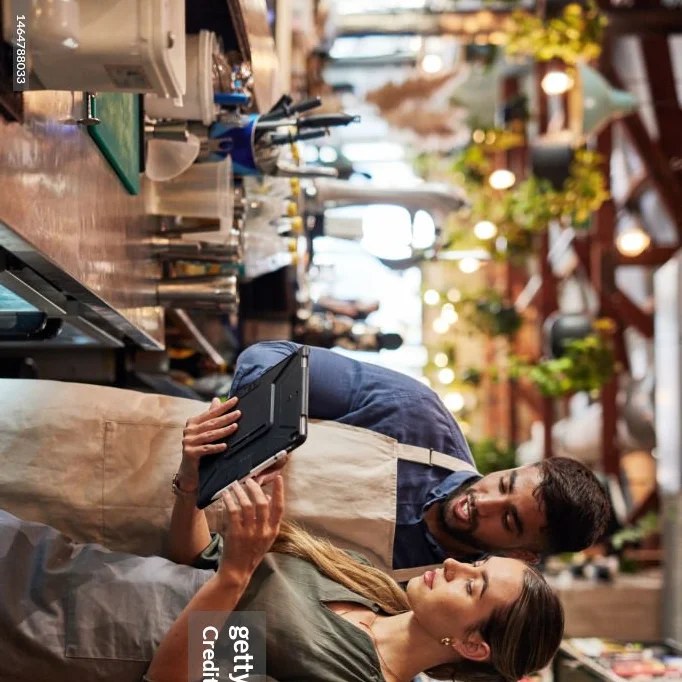 Staff collaborating in a modern restaurant with a tablet