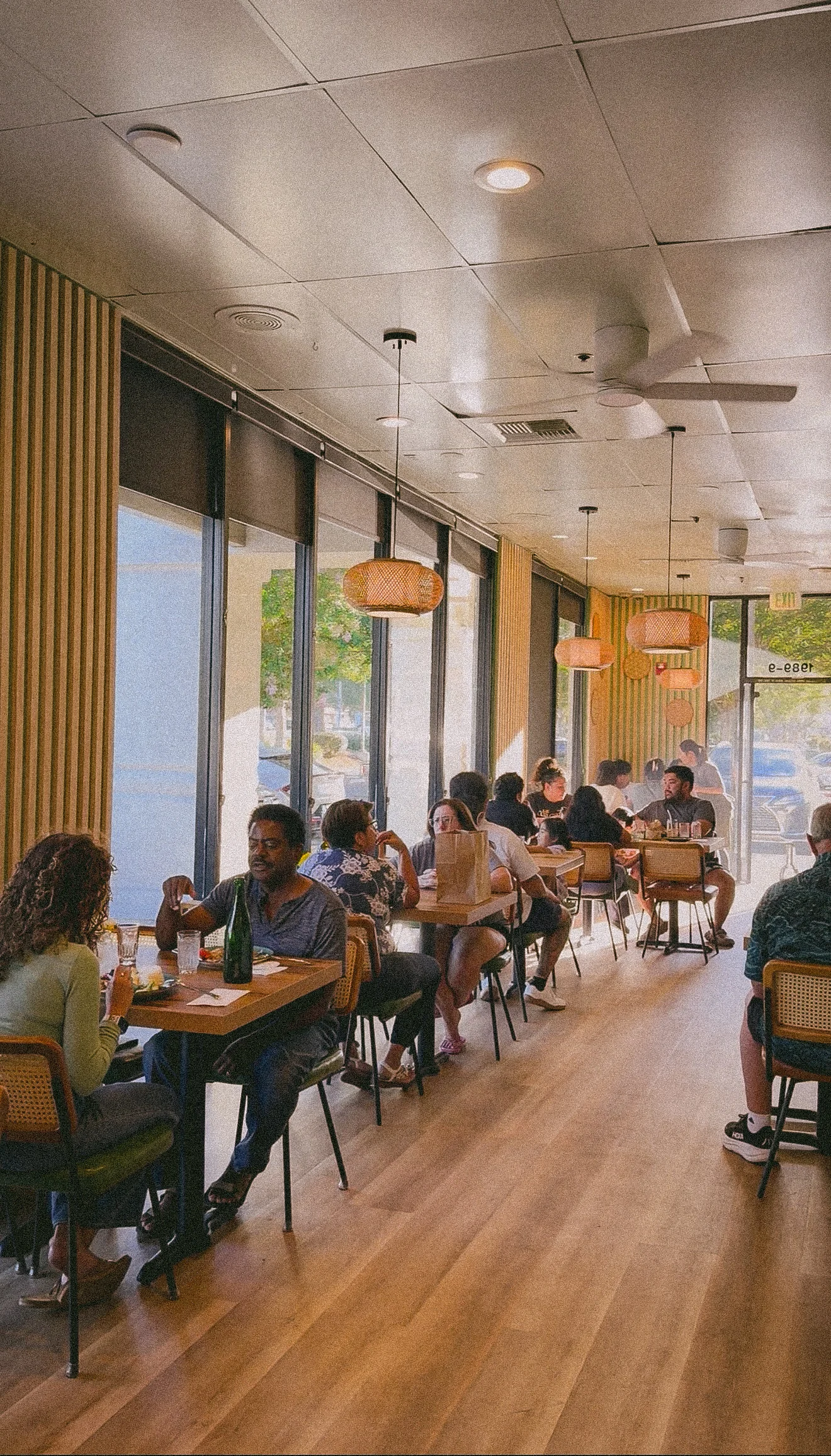 Bright restaurant interior with diners enjoying meals and natural light