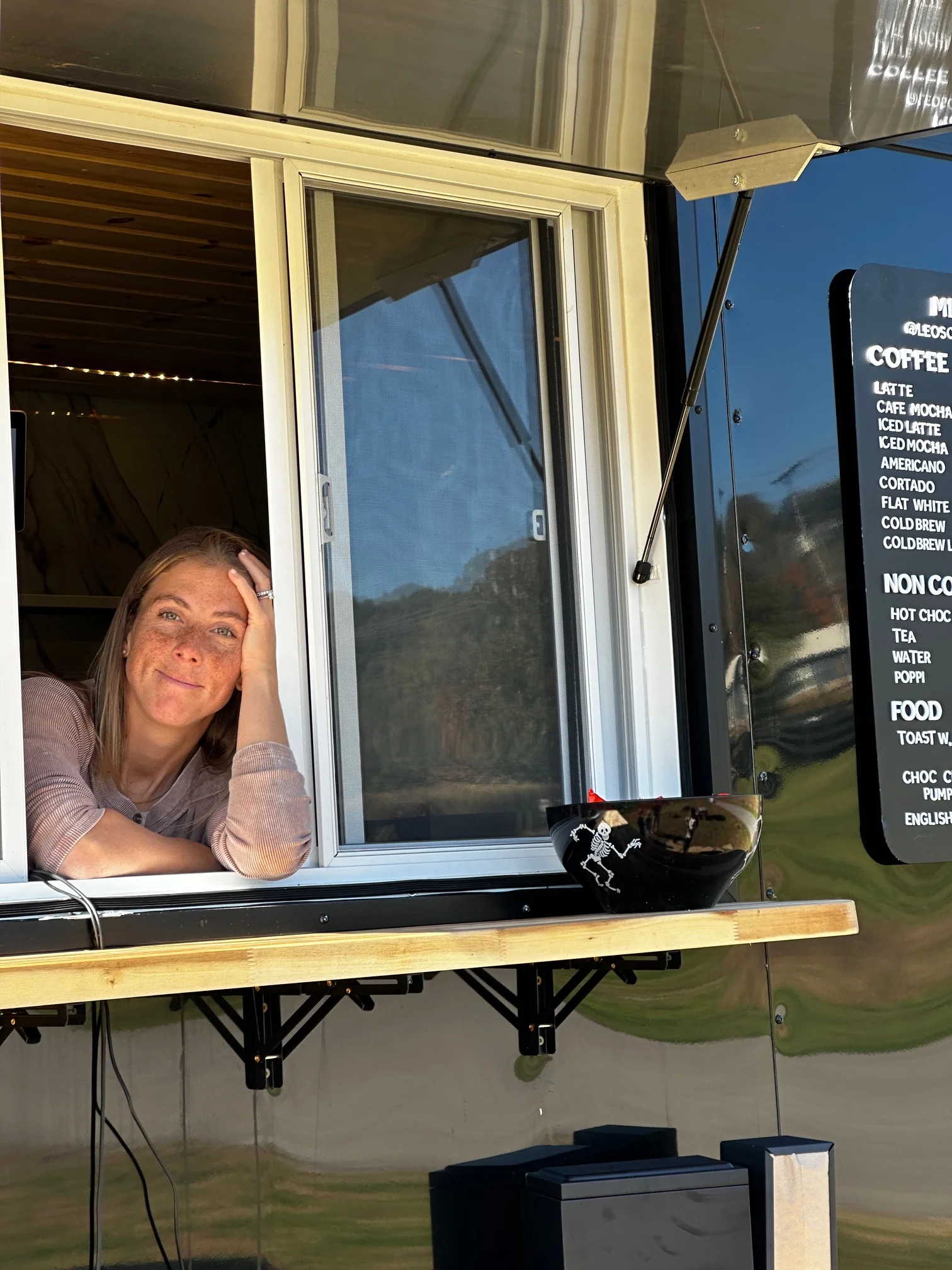 Coffee truck window with a friendly barista