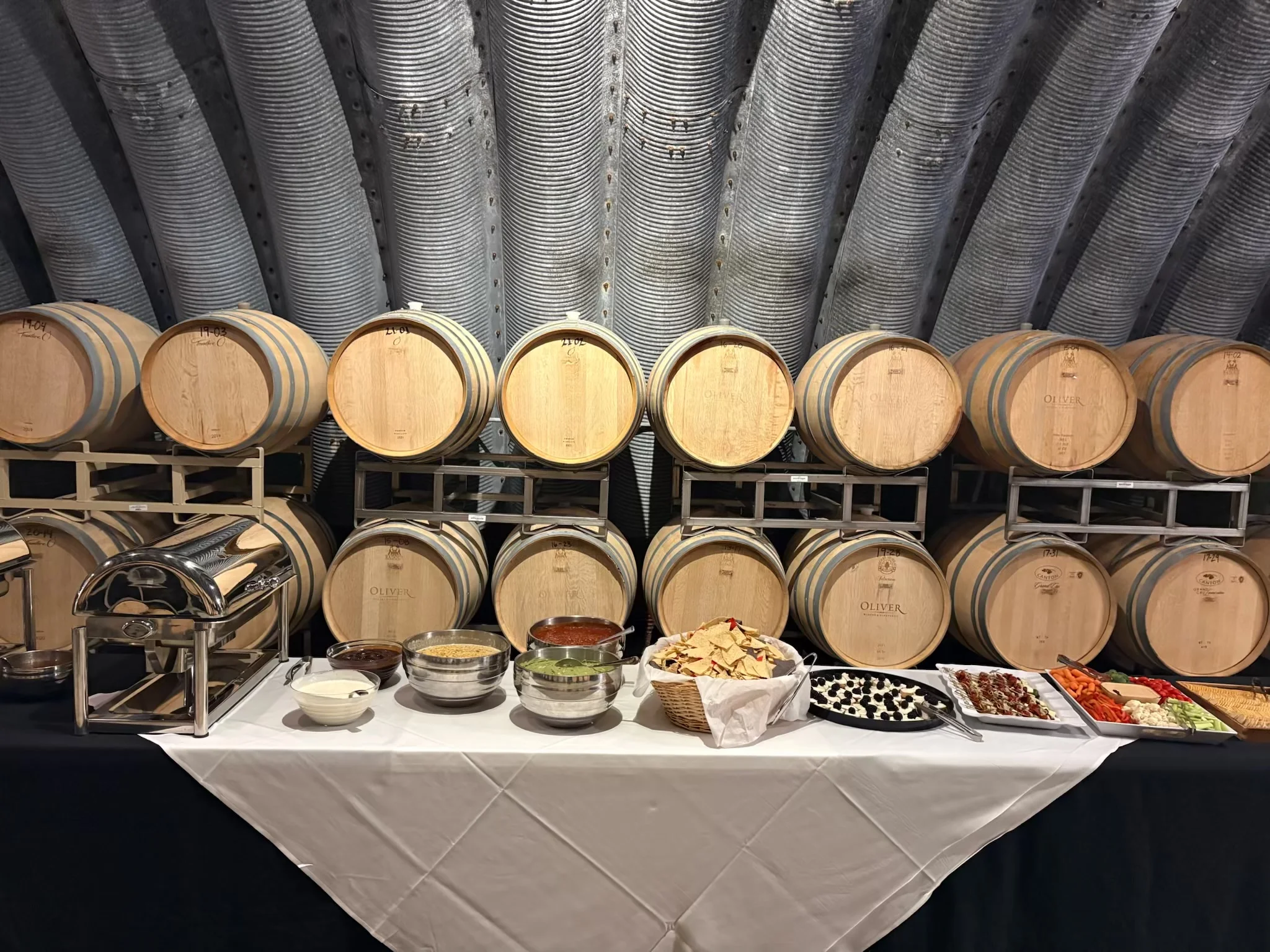 Elegant buffet setup with wine barrels in a rustic venue