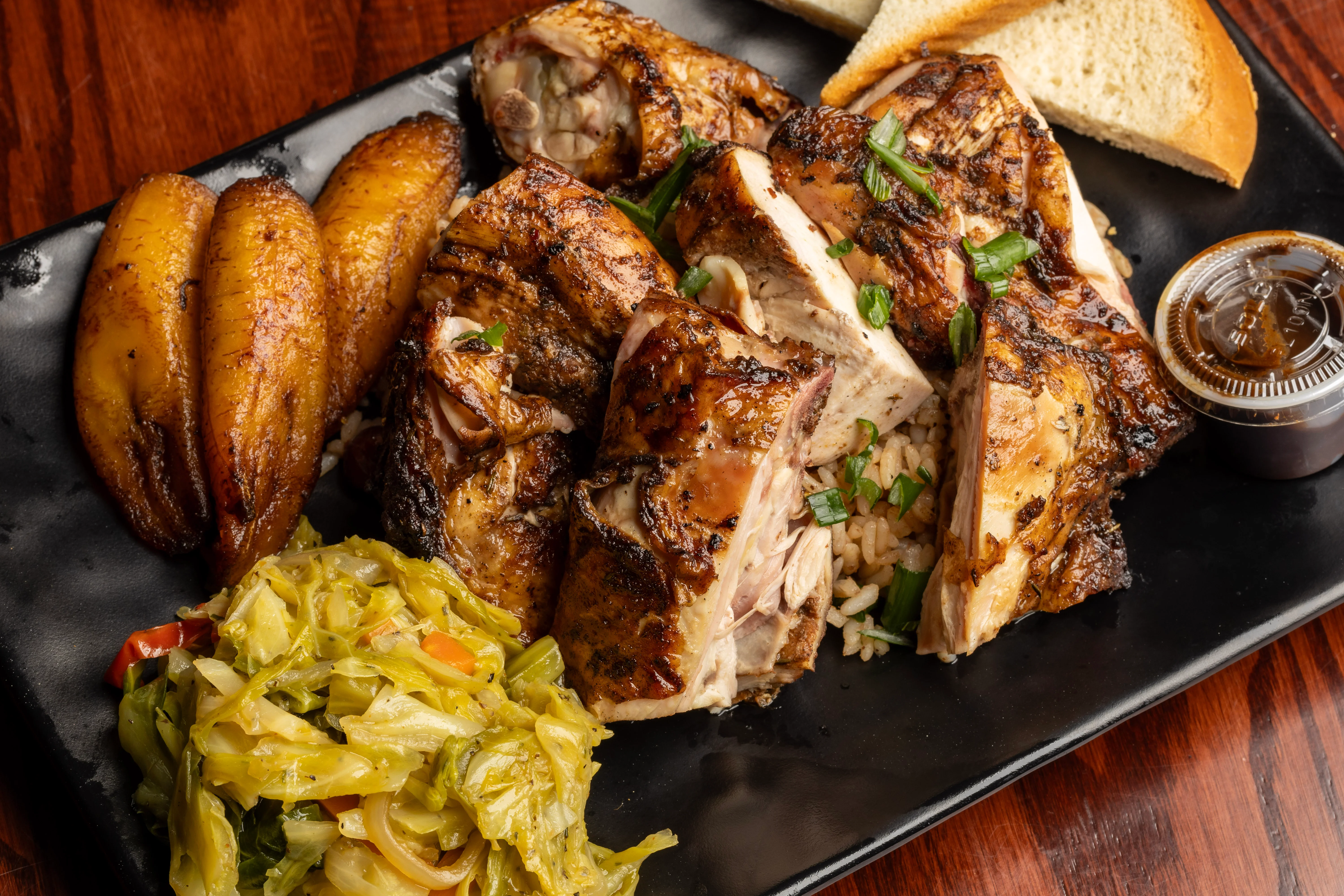 Jamaican jerk chicken platter with plantains and cabbage