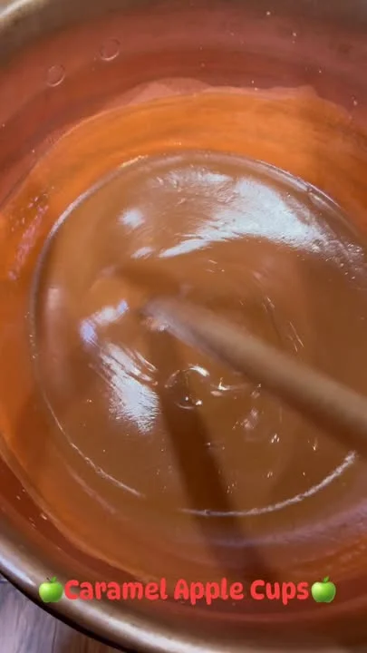 A smooth, thick caramel mixture being stirred in a bowl, perfect for making treats.