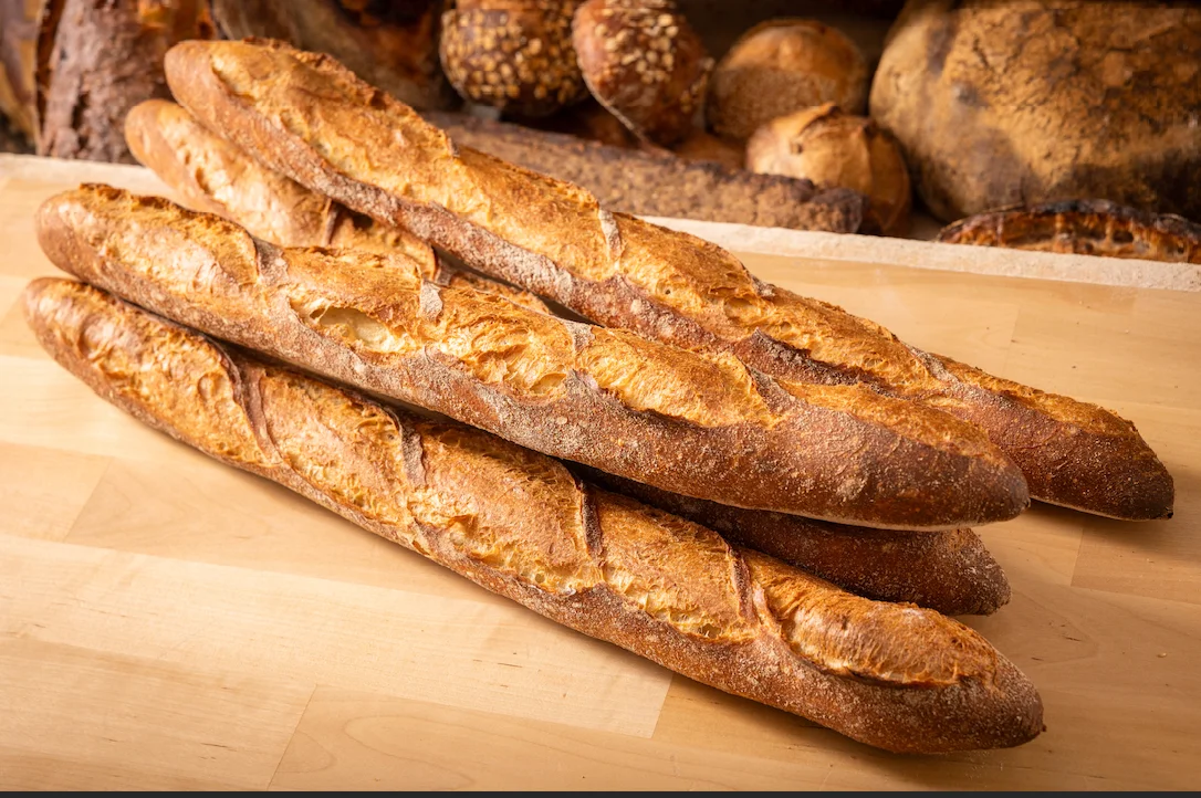 Freshly baked French baguettes on a wooden surface