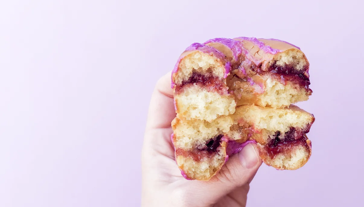 Colorful jelly-filled donut with purple icing