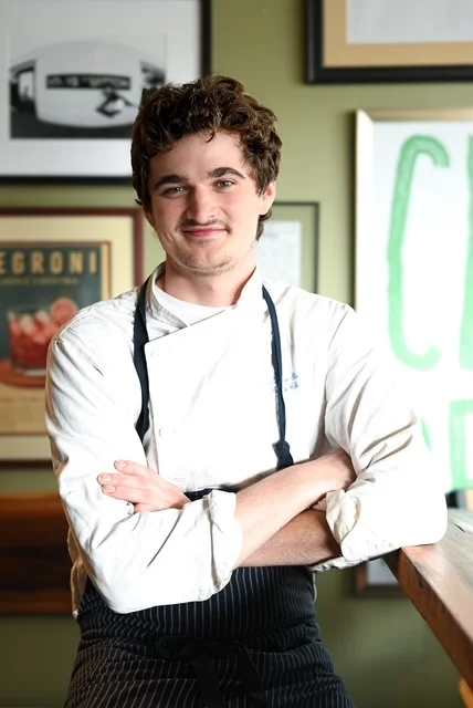 Chef posing confidently in a stylish restaurant interior