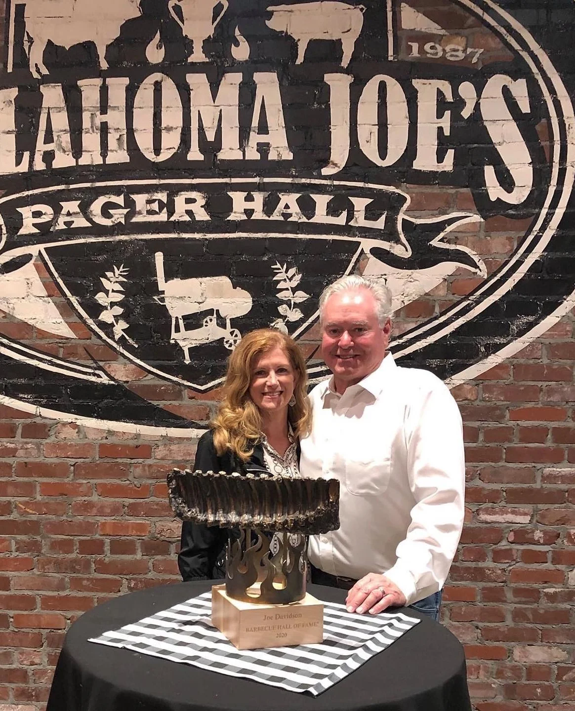 Couple celebrating at Oklahoma Joe's with a barbecue hall of fame trophy