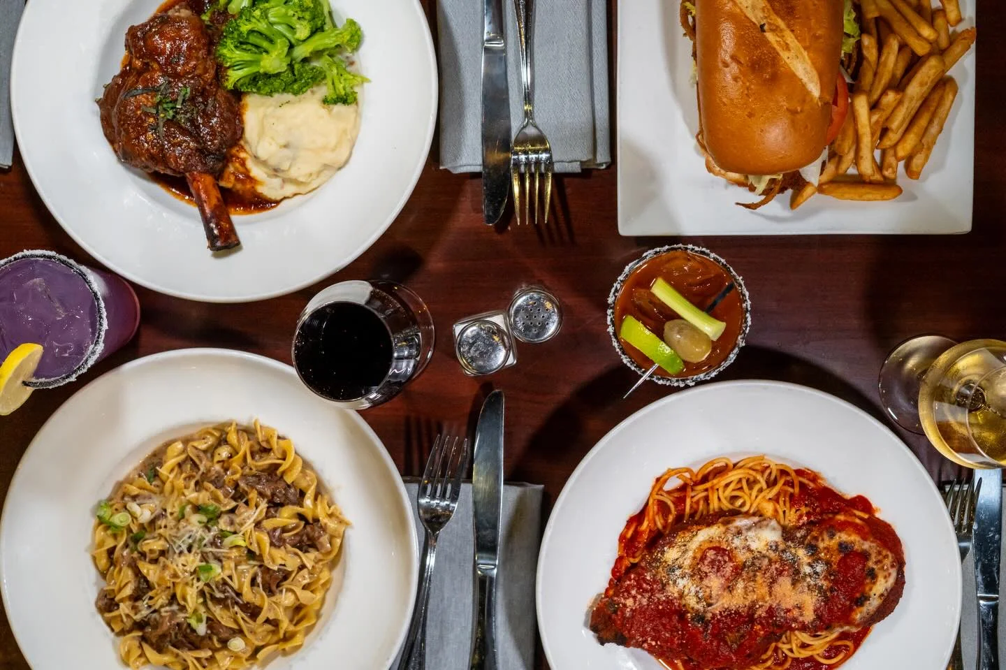 An assortment for Dishes, Lamb shank, Chicken Parm, Beef Stroganoff, Sandwiches, wine, blood Mary