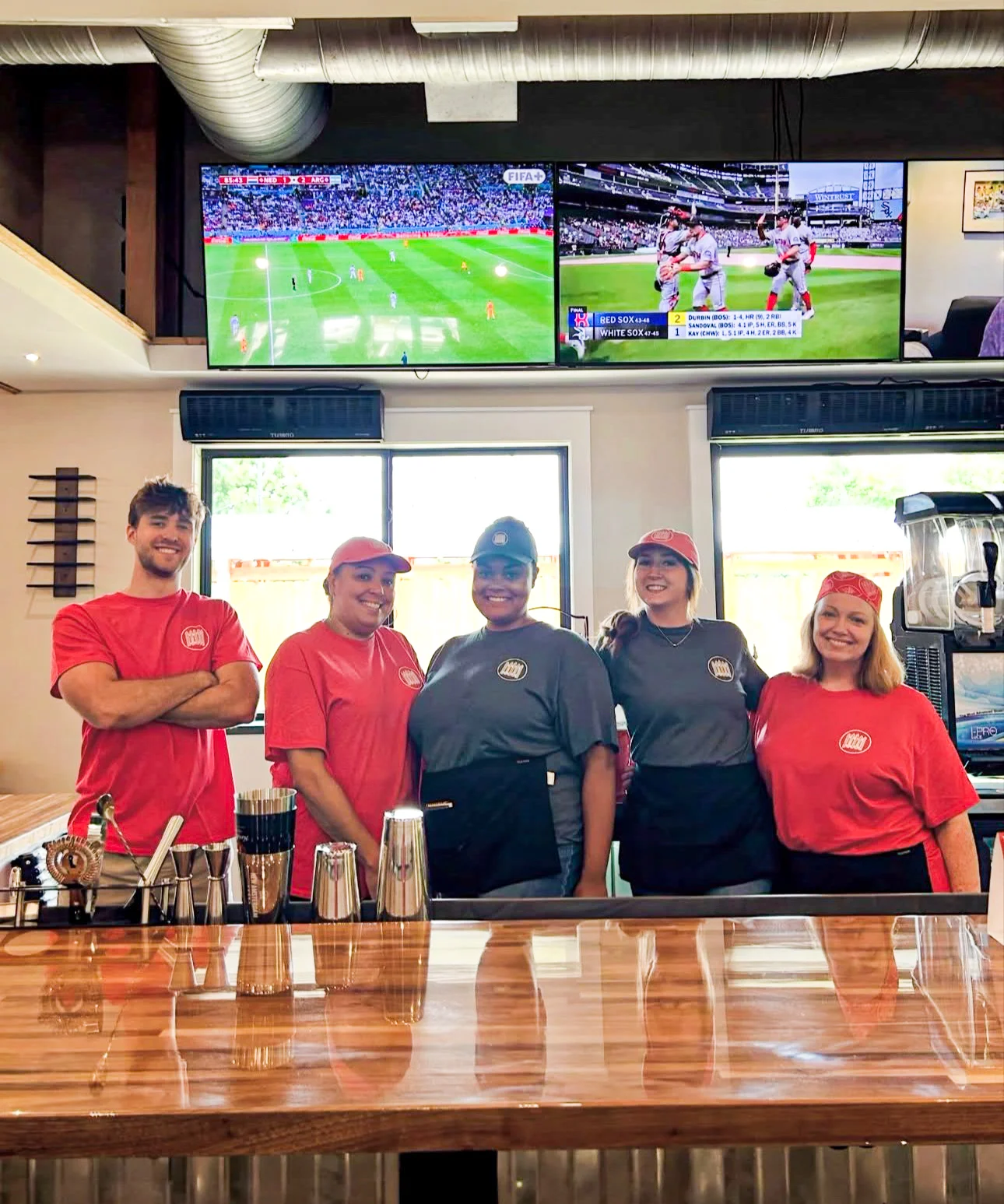 Friendly restaurant staff posing at the bar counter